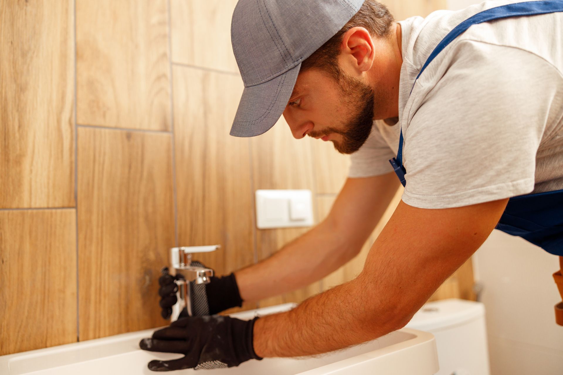 male plumber installing bathroom facet