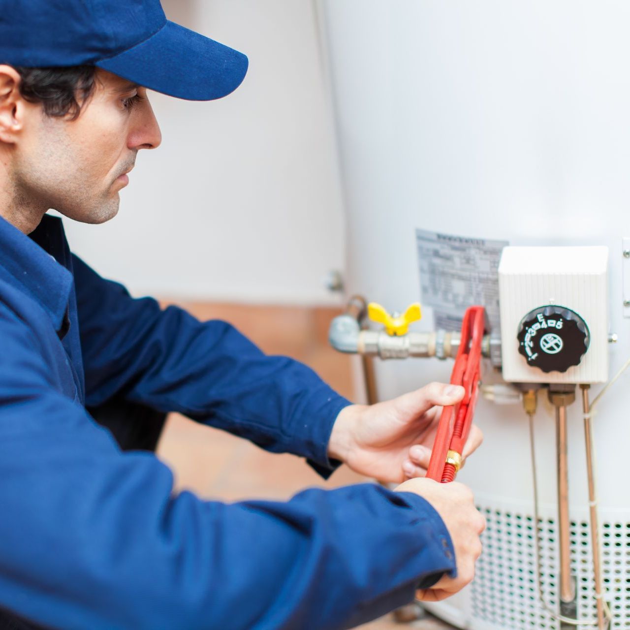 professional residential plumber during hot water heater repair service