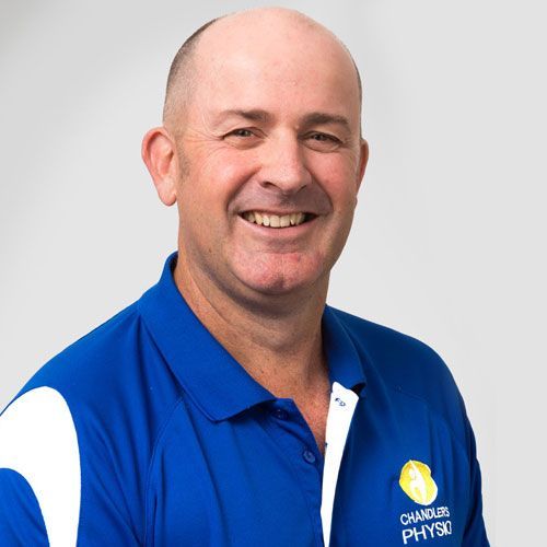 Man smiling, wearing a blue polo shirt with 