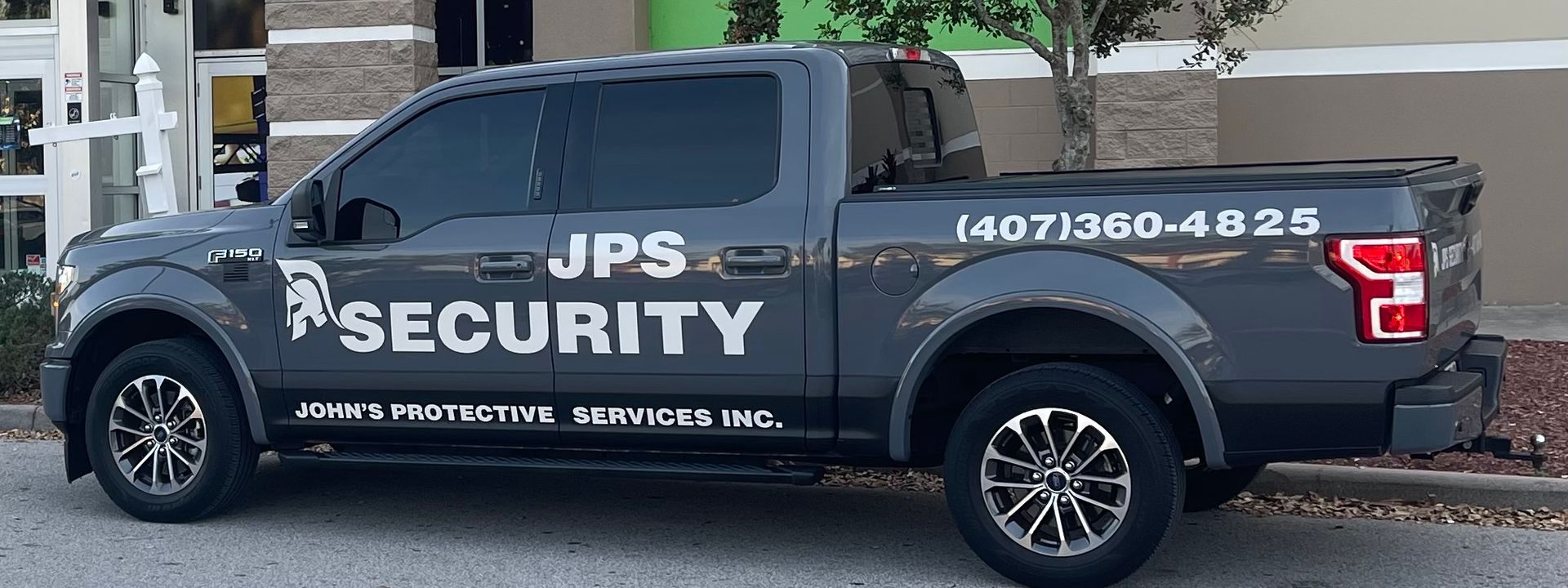 A dark gray pickup truck parked outdoors, labeled with 