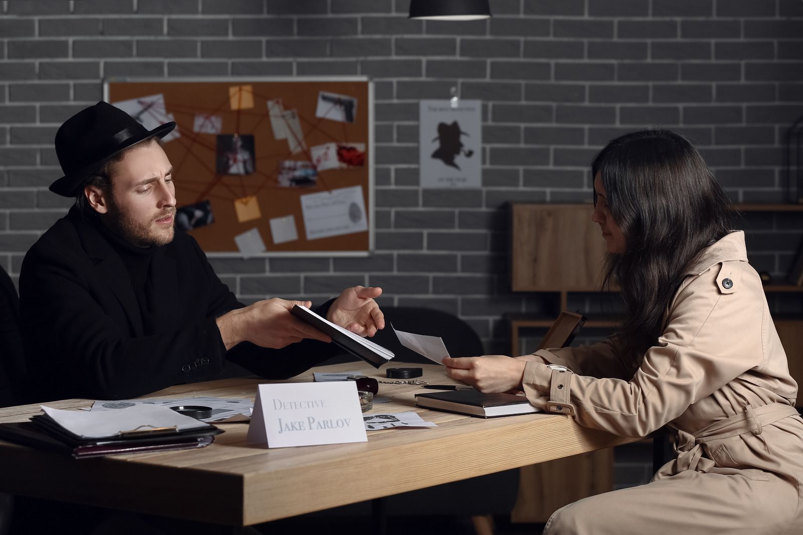 A man and a woman are sitting at a table talking to each other.