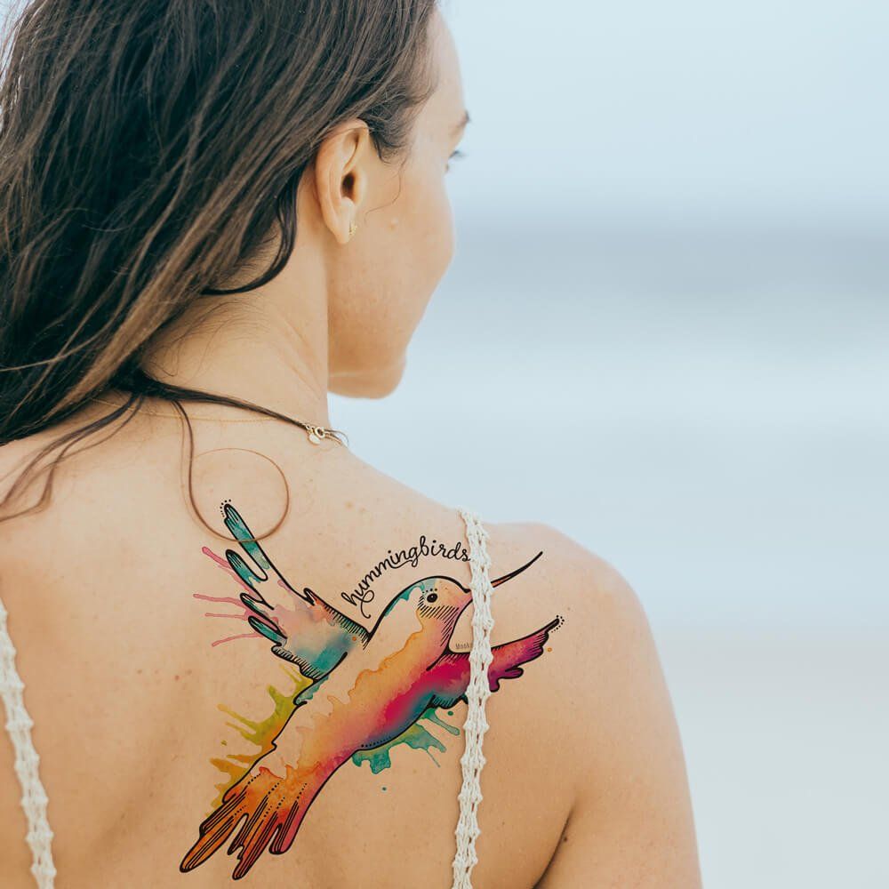 Bright rainbow coloured splashy watercolour hummingbird ladies shoulder tattoo, illustrated by MooksGoo