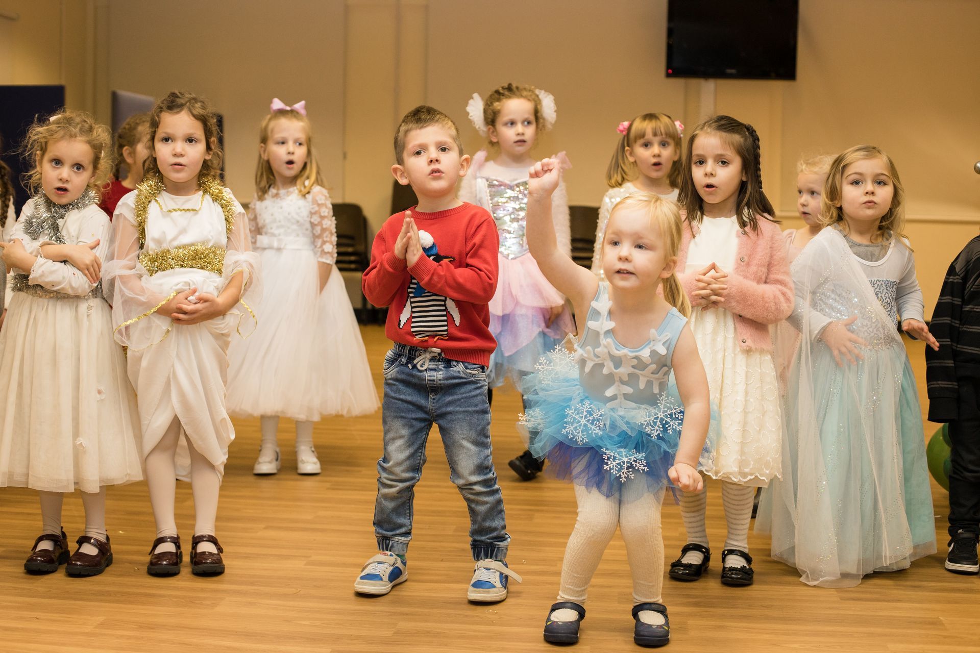 Группа детей стоит рядом друг с другом на танцплощадке.