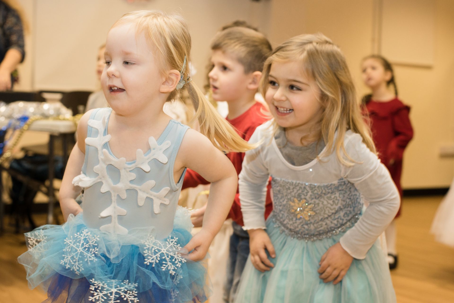 Две маленькие девочки в ледяных костюмах стоят рядом друг с другом.