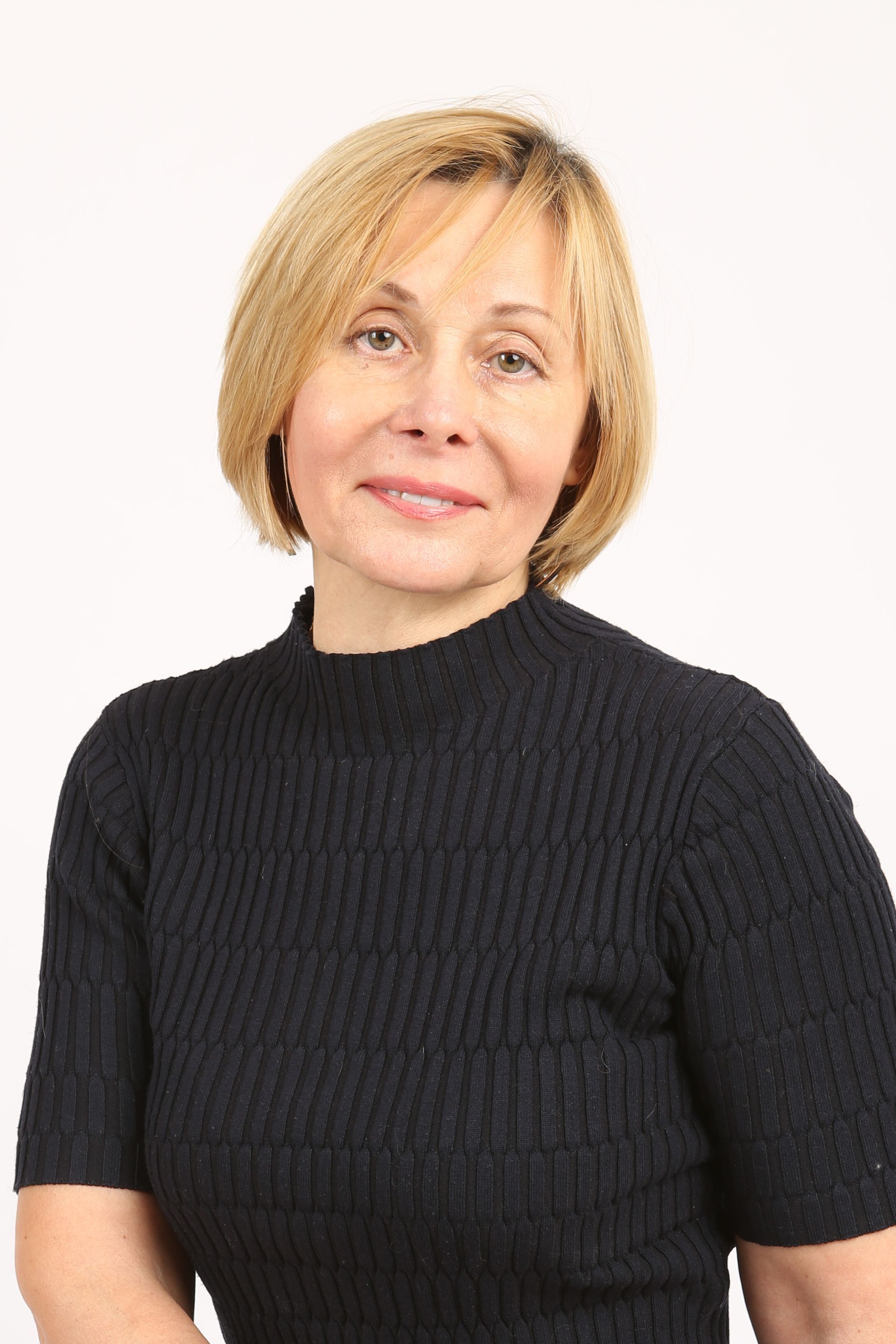 Женщина в черном свитере улыбается в камеру.