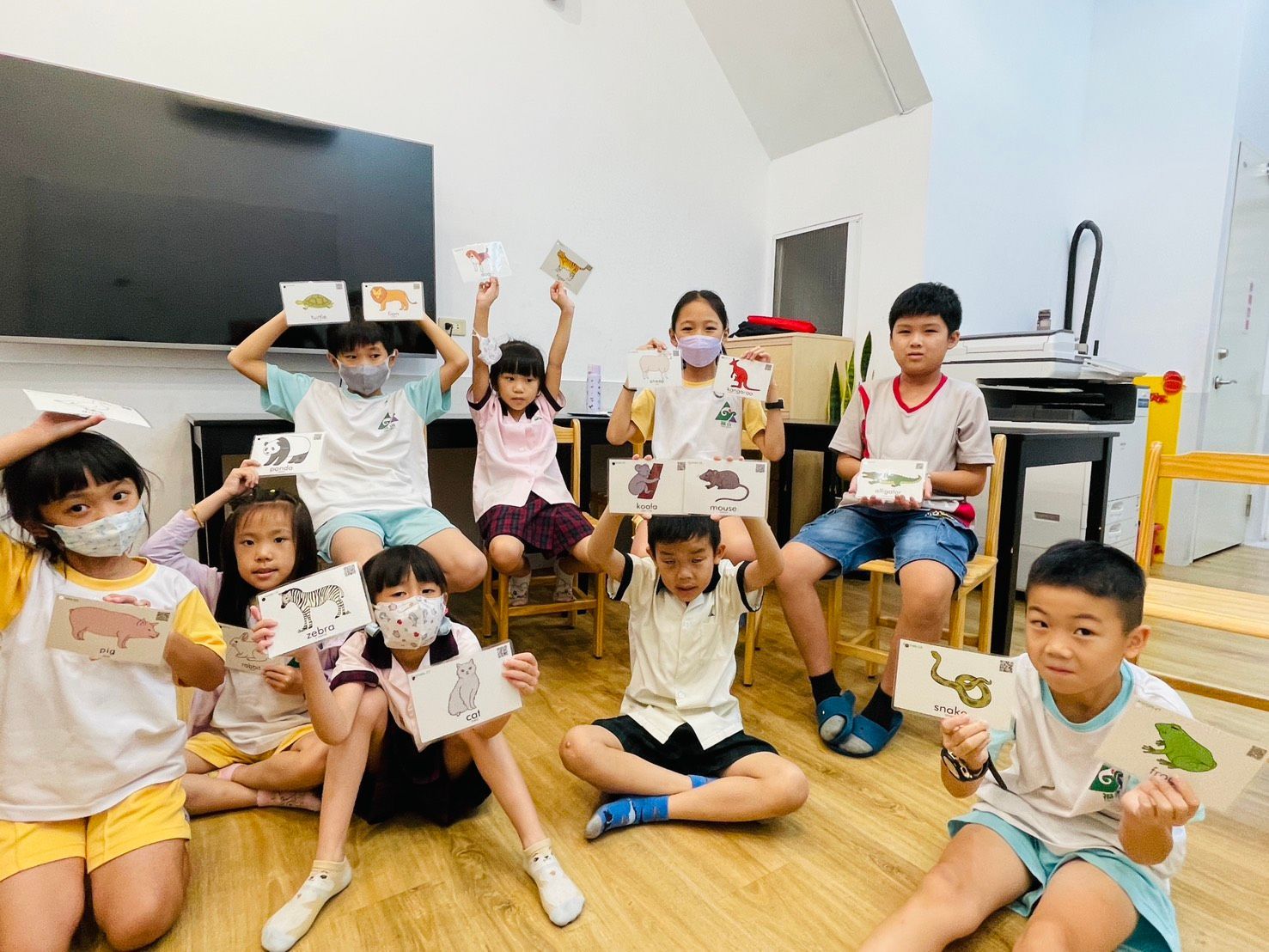 孩子們在教室裡舉著動物閃卡。