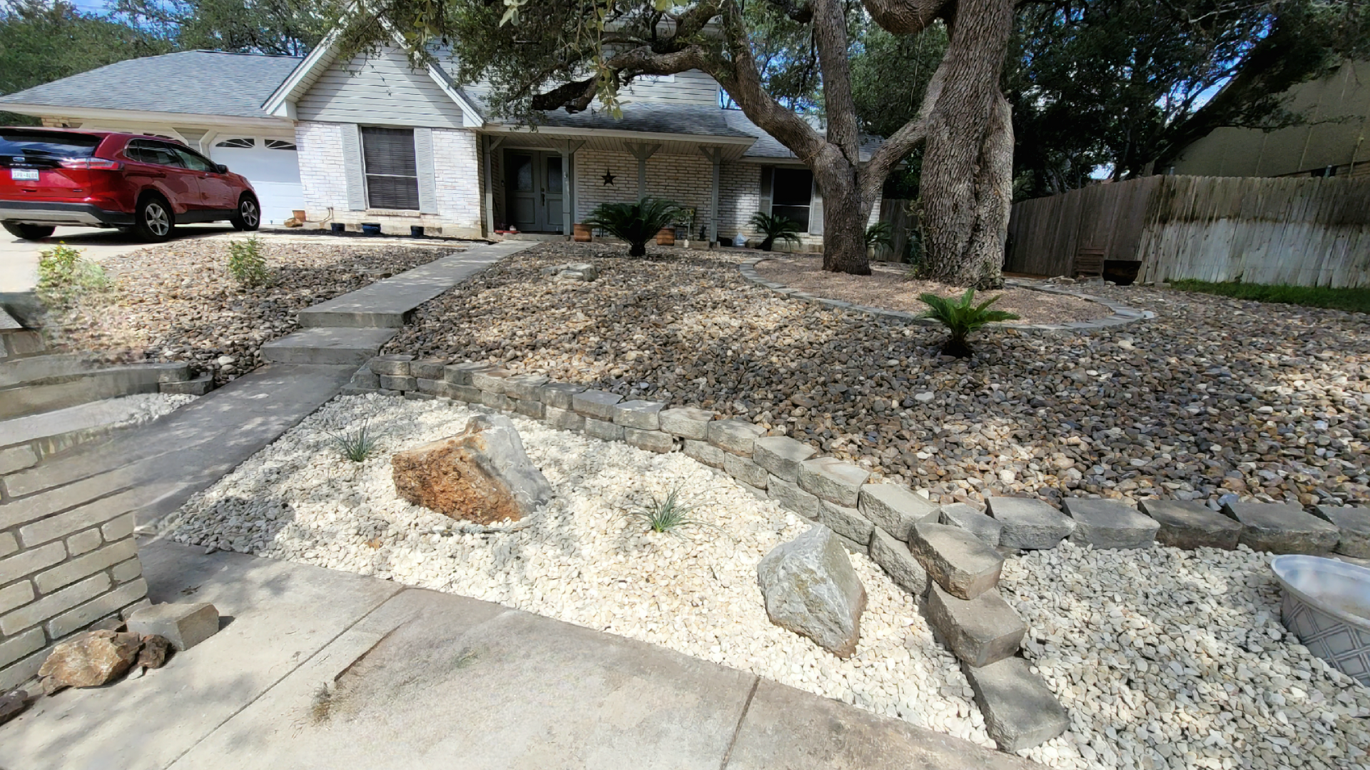 A red car is parked in front of a house