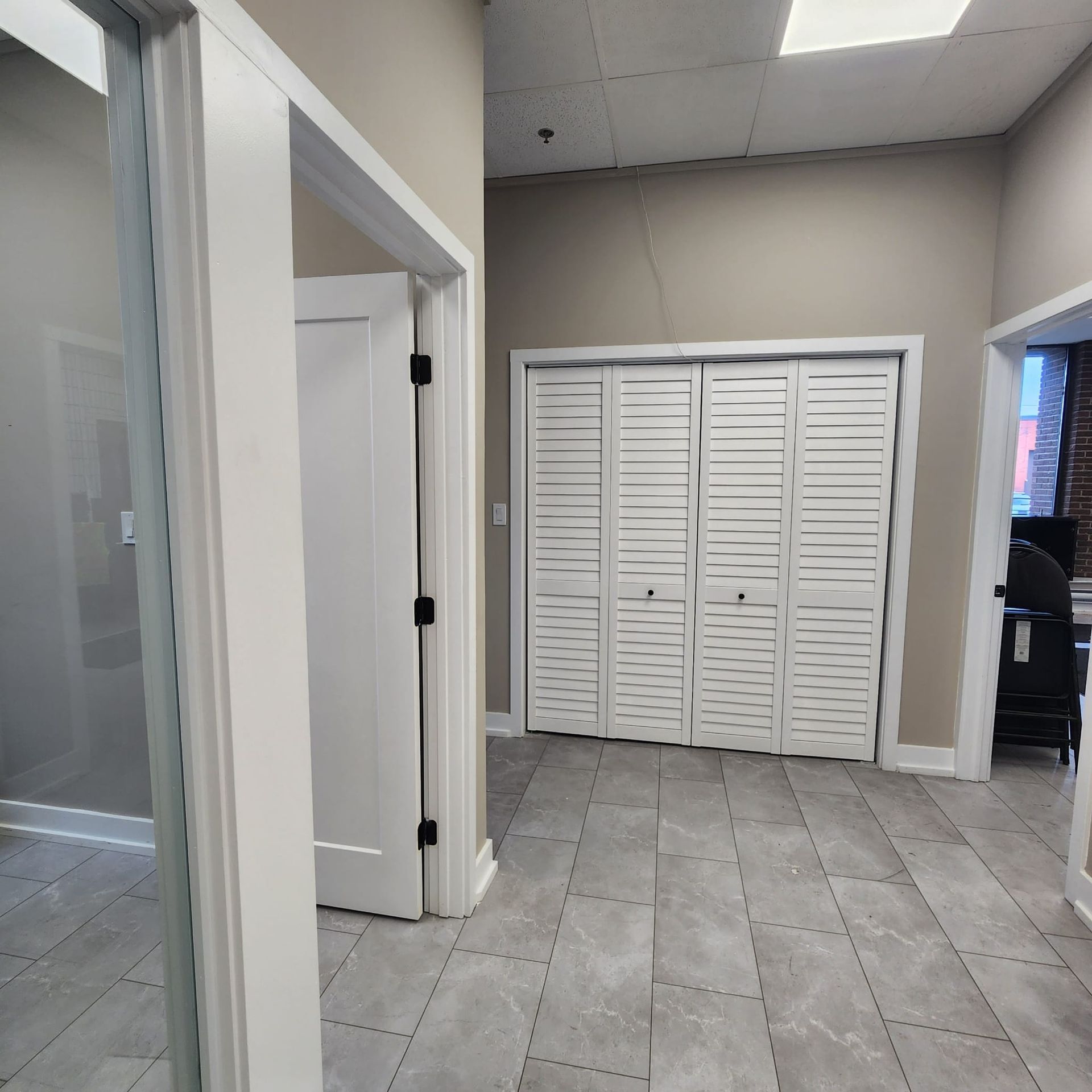 Hallway with tile floor, white doors, and a closed folding door closet.