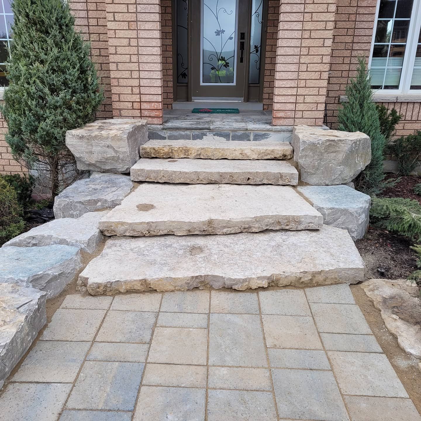 Stone steps and walkway leading to a brick home's front door.