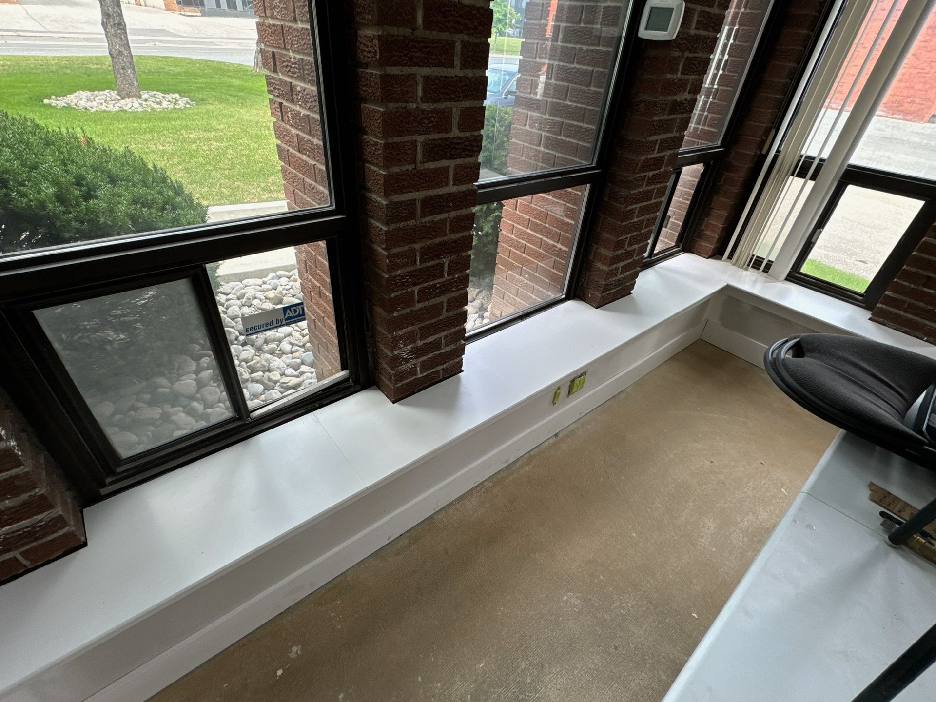 Interior sunroom with brick columns, windows, and white trim.