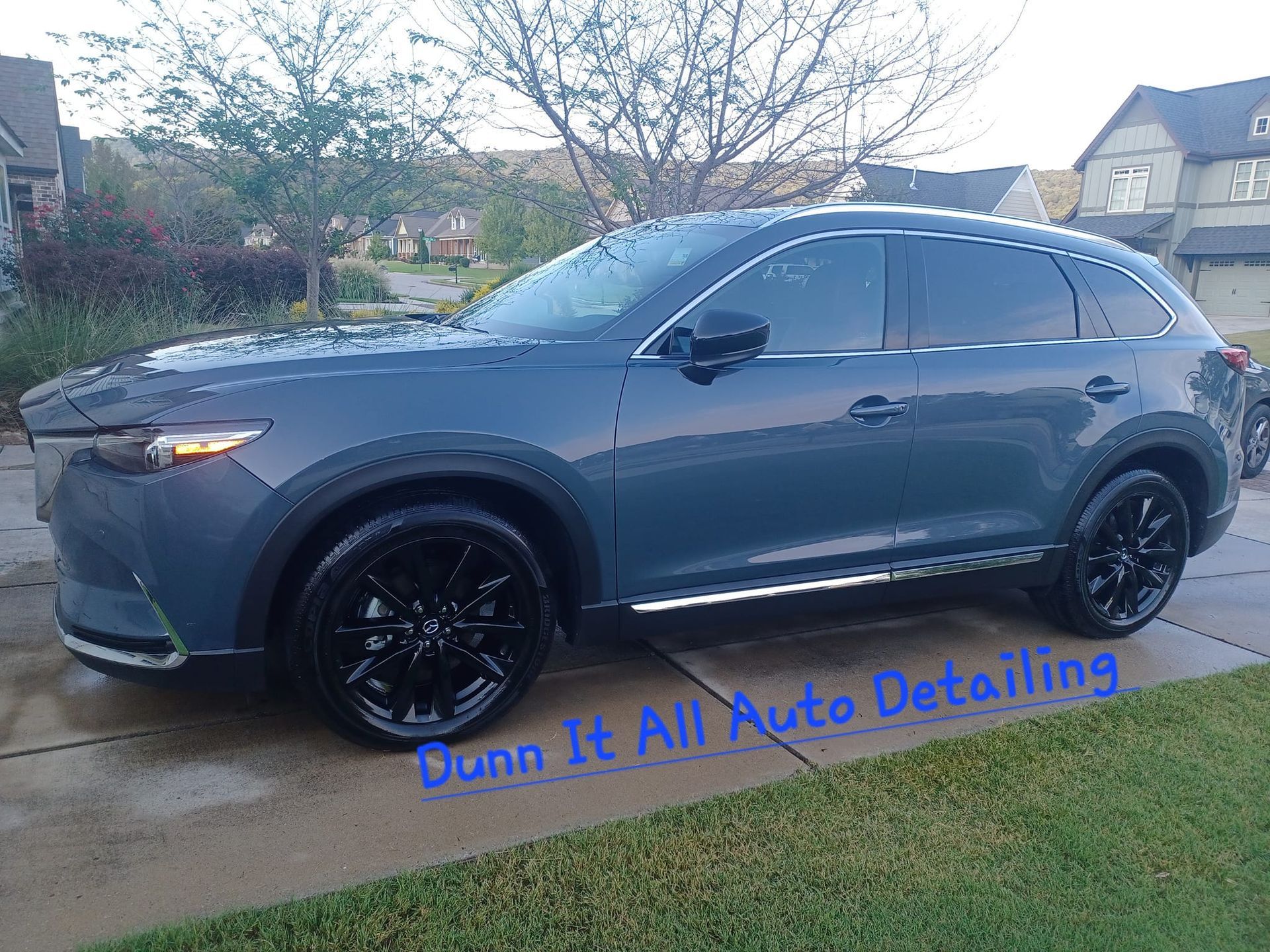 a mazda cx 9 is parked on the side of the road .
