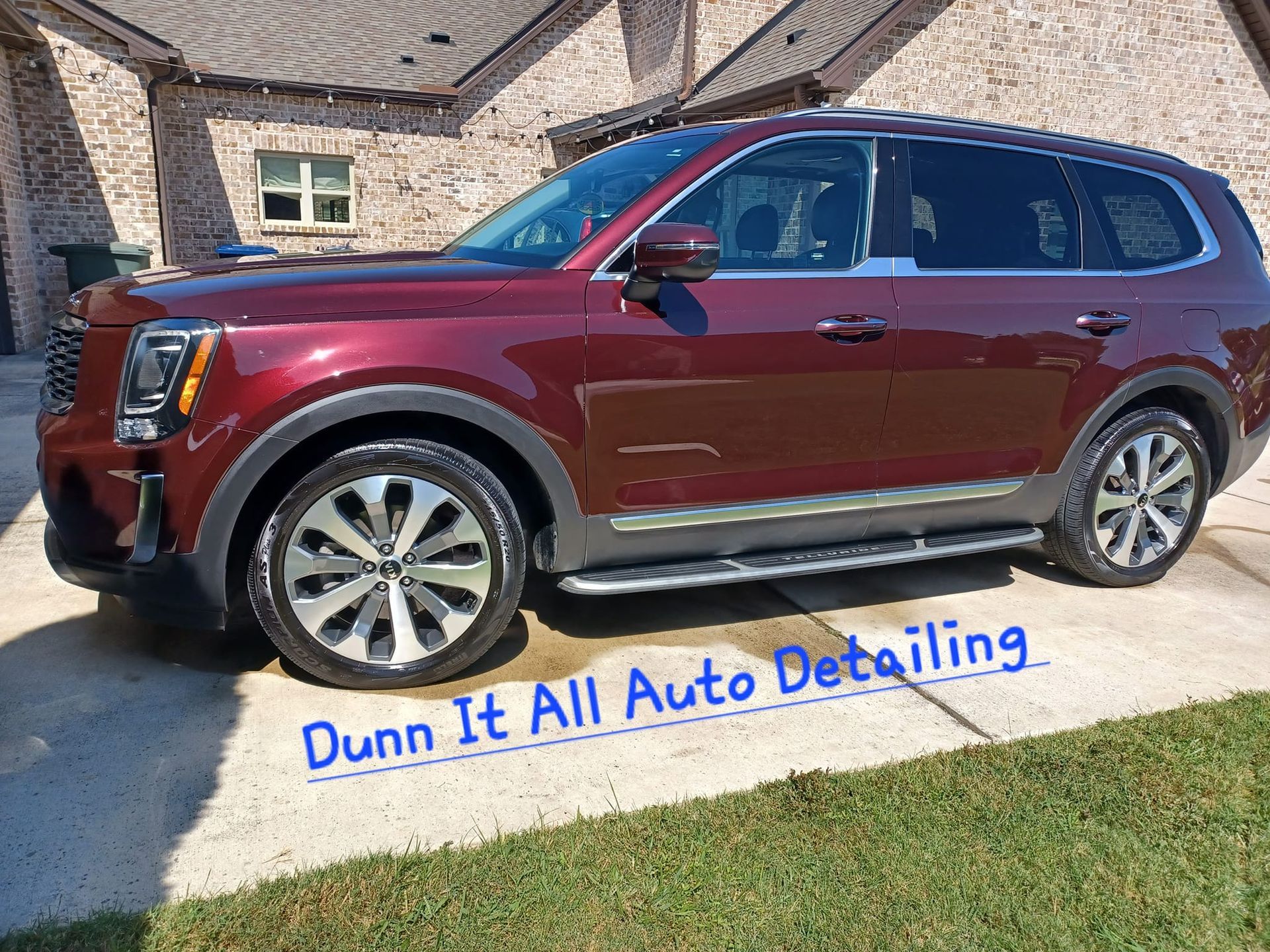 a red suv is parked in front of a brick house .