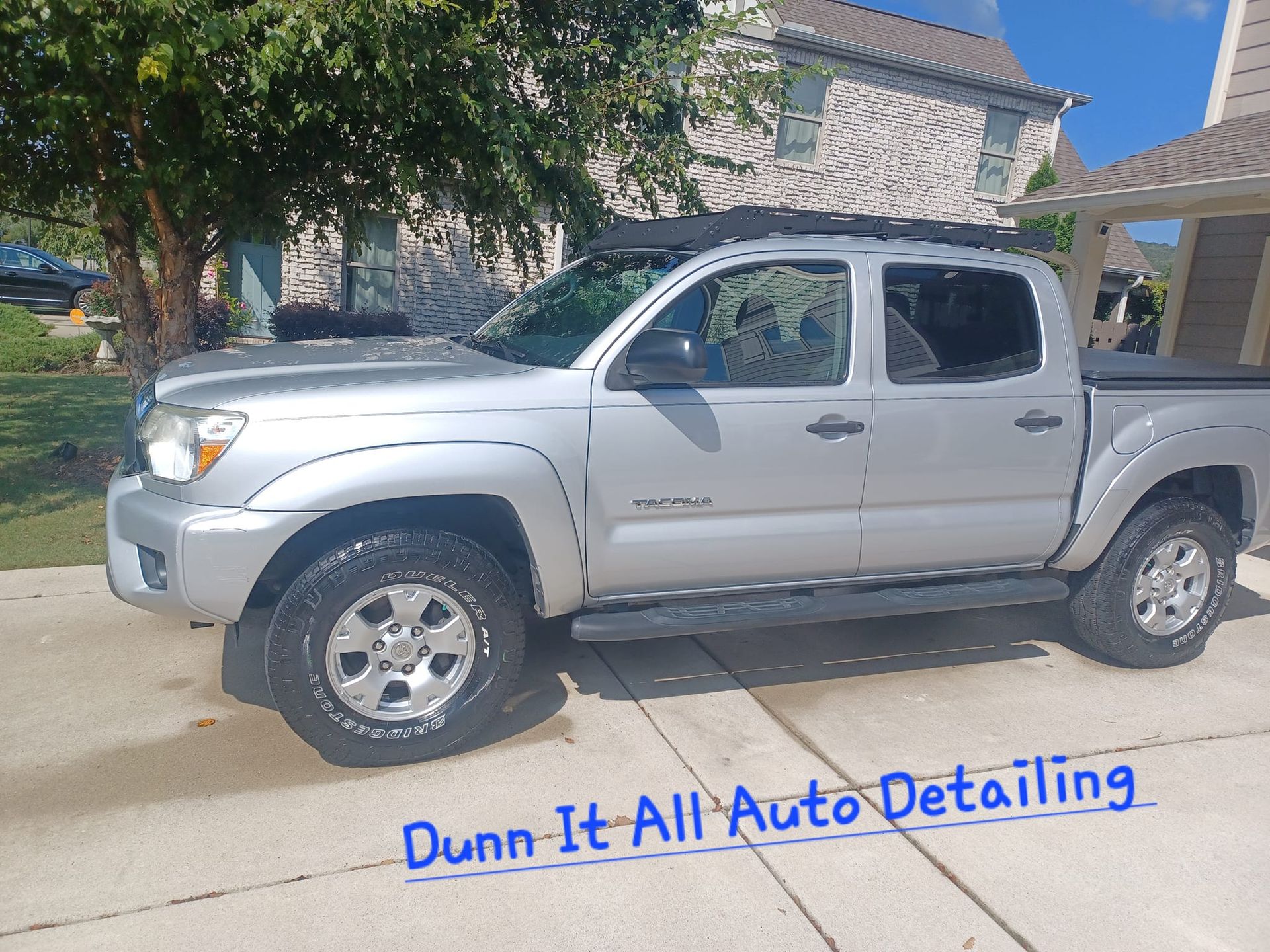a silver truck is parked on the side of the road in front of a house .