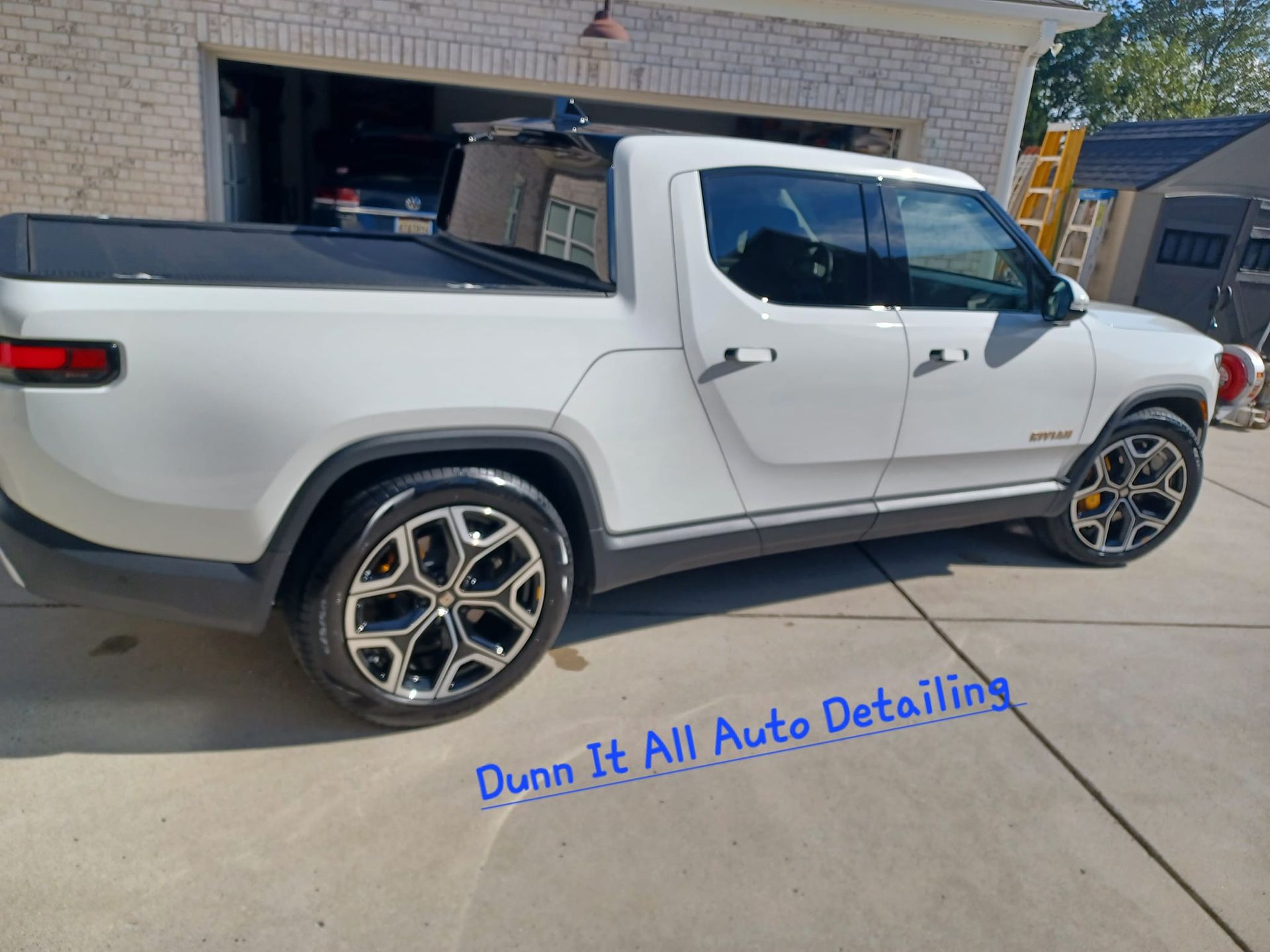 a white truck is parked in front of a garage .