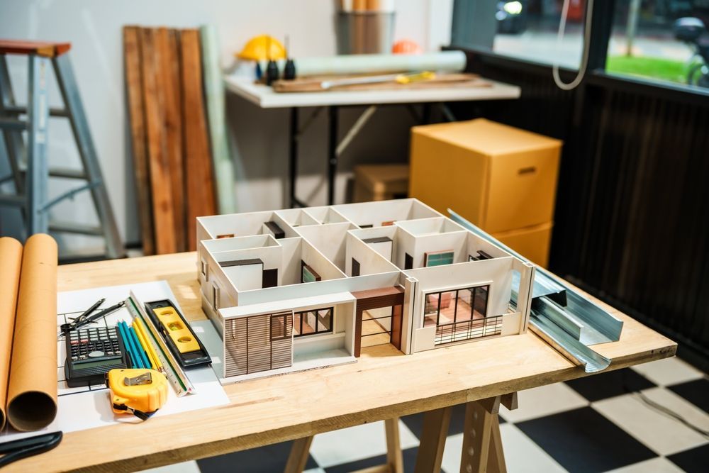 A model of a house is sitting on a wooden table.