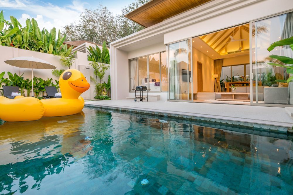 A large house with a swimming pool in front of it.