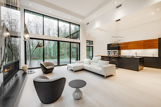 A kitchen with a large island and a dining room with a table and chairs.