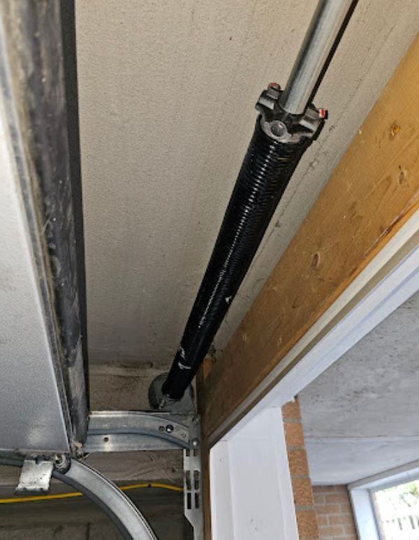A close up of a garage door spring in a garage