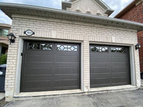 There are two garage doors on the side of a house.