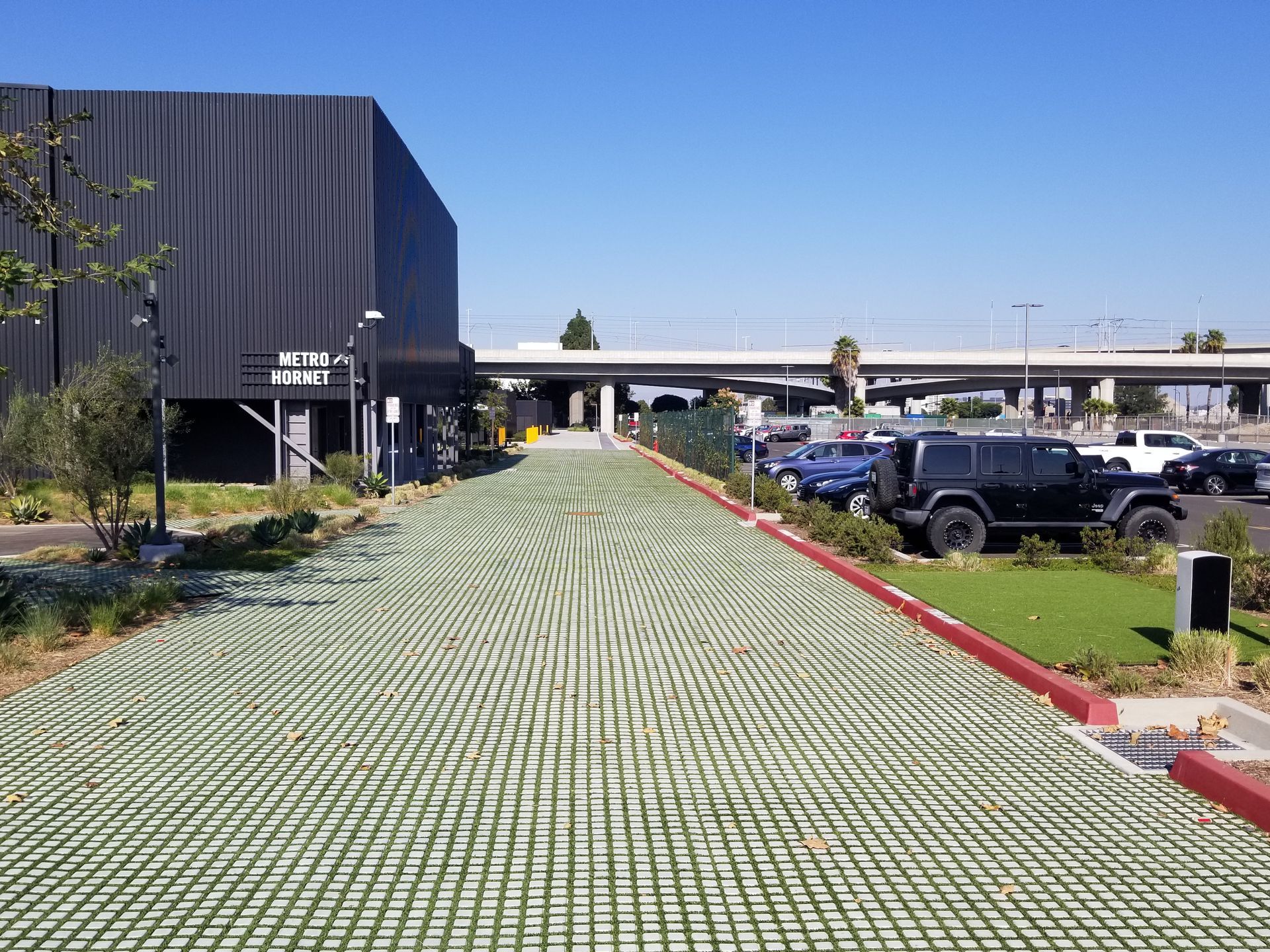 A jeep is parked on the side of the road in front of a building.