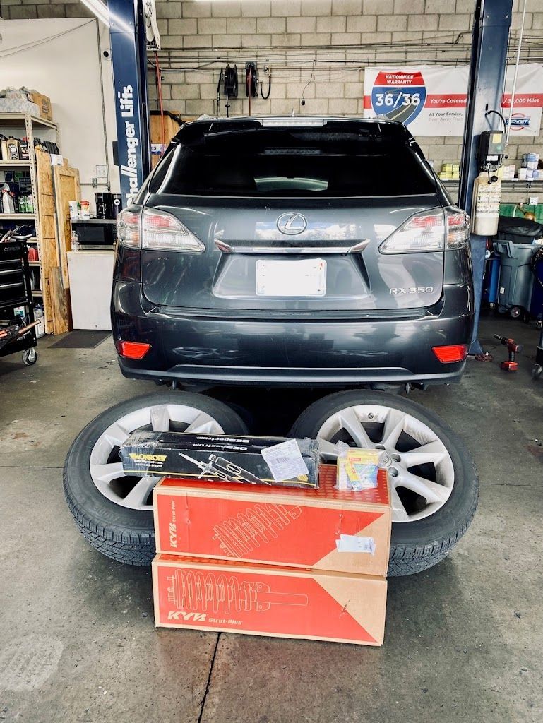 Gray SUV with tires and boxes in a garage. | Nutech Auto Repair
