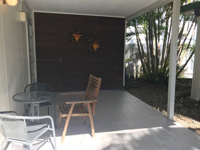 A Patio With A Table And Chairs Under A Canopy — Bush Village Holiday Cabins In Cannonvale, QLD