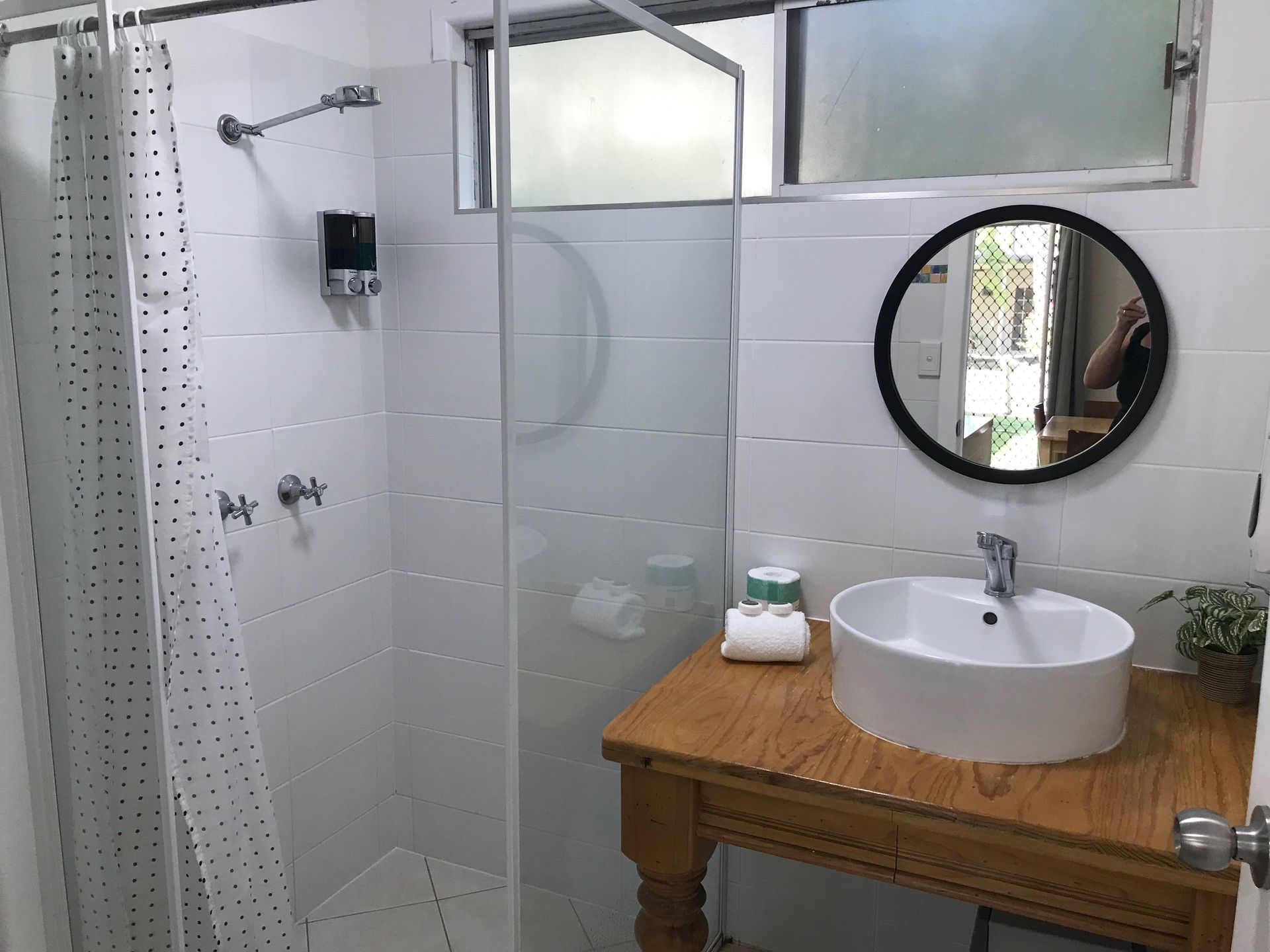 A Bathroom With A Sink, Mirror And Shower — Bush Village Holiday Cabins In Cannonvale, QLD