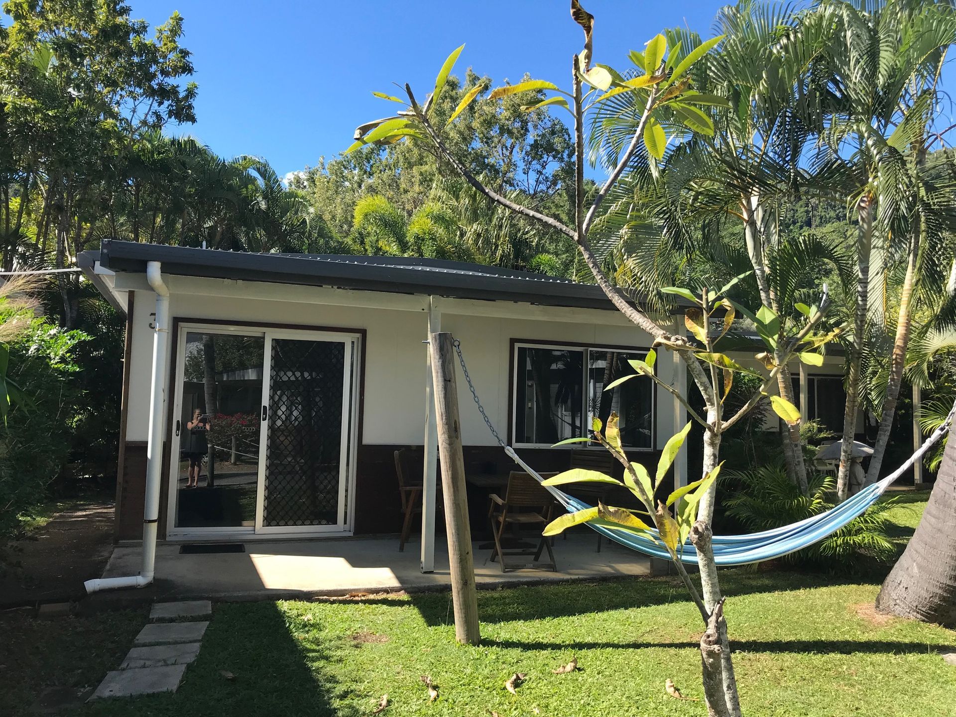 A Small House With A Hammock In Front Of It — Bush Village Holiday Cabins In Cannonvale, QLD