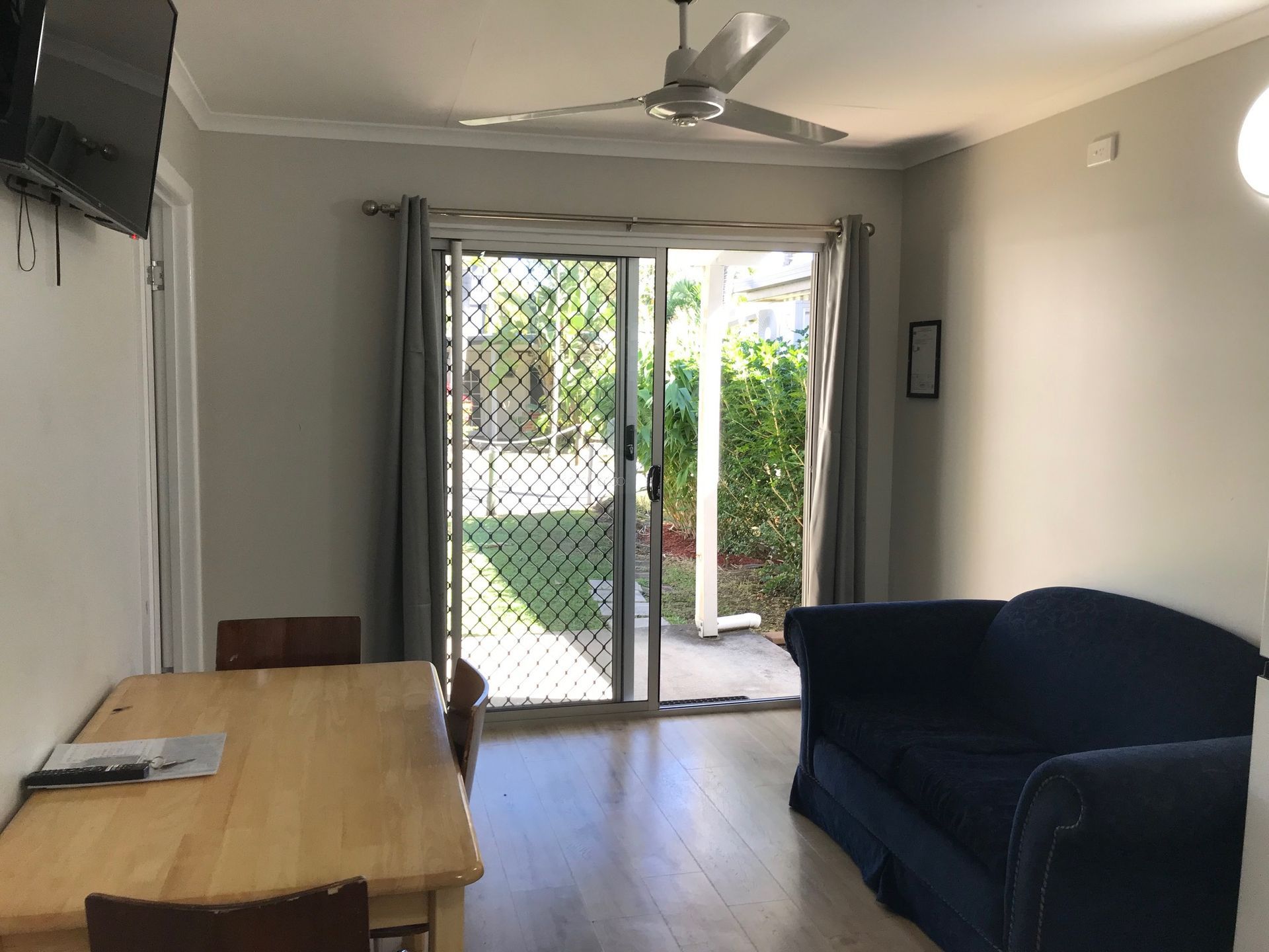 A Living Room With A Couch A Table And A Ceiling Fan — Bush Village Holiday Cabins In Cannonvale, QLD