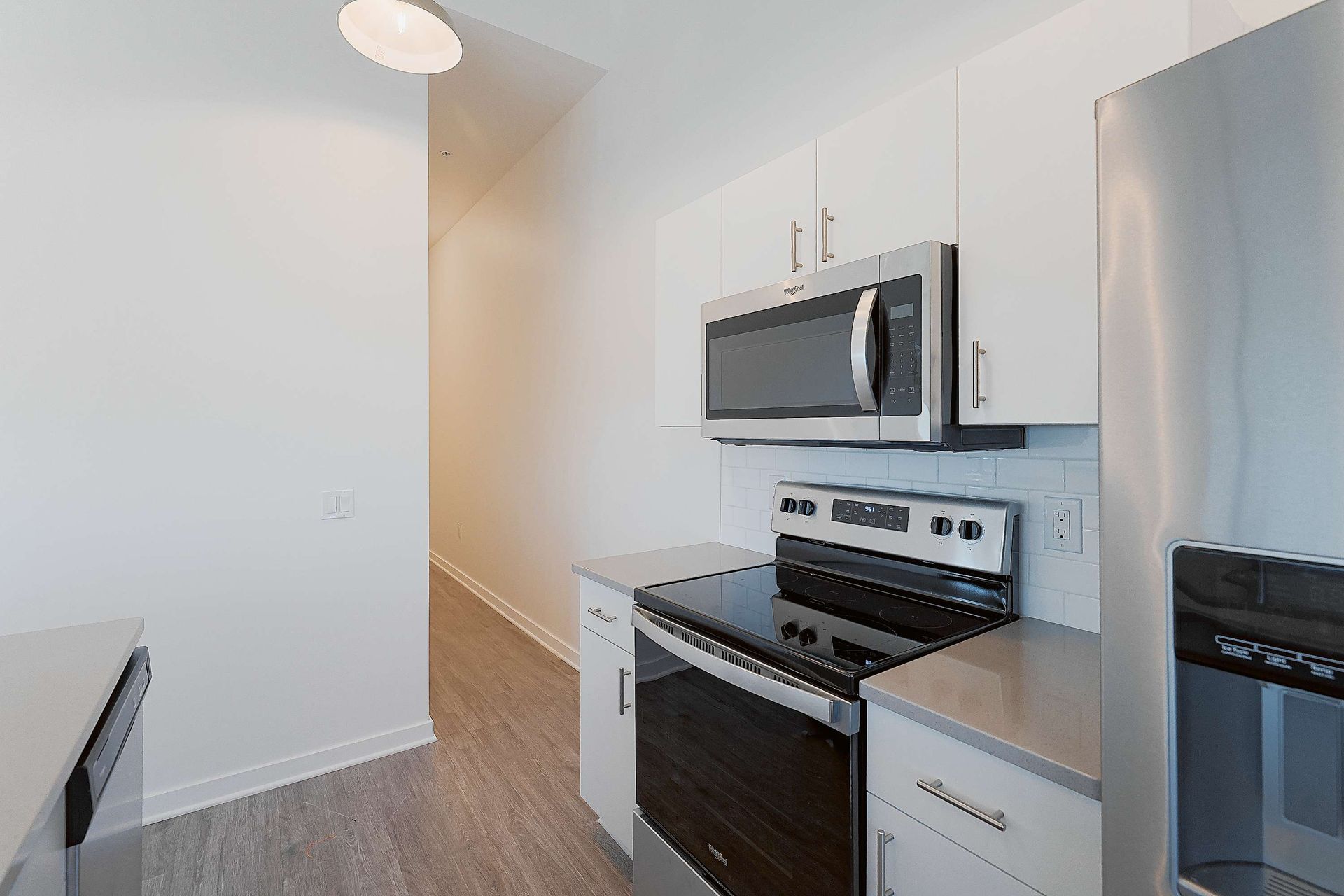 A kitchen with a stove , microwave , refrigerator and sink.