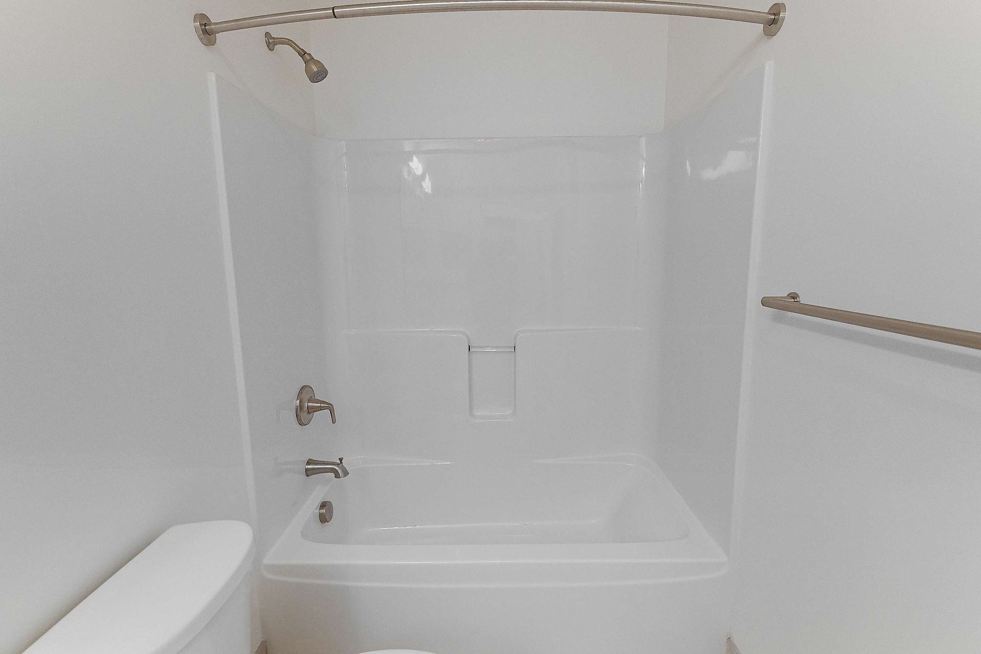 A bathroom with a bathtub , toilet and shower.