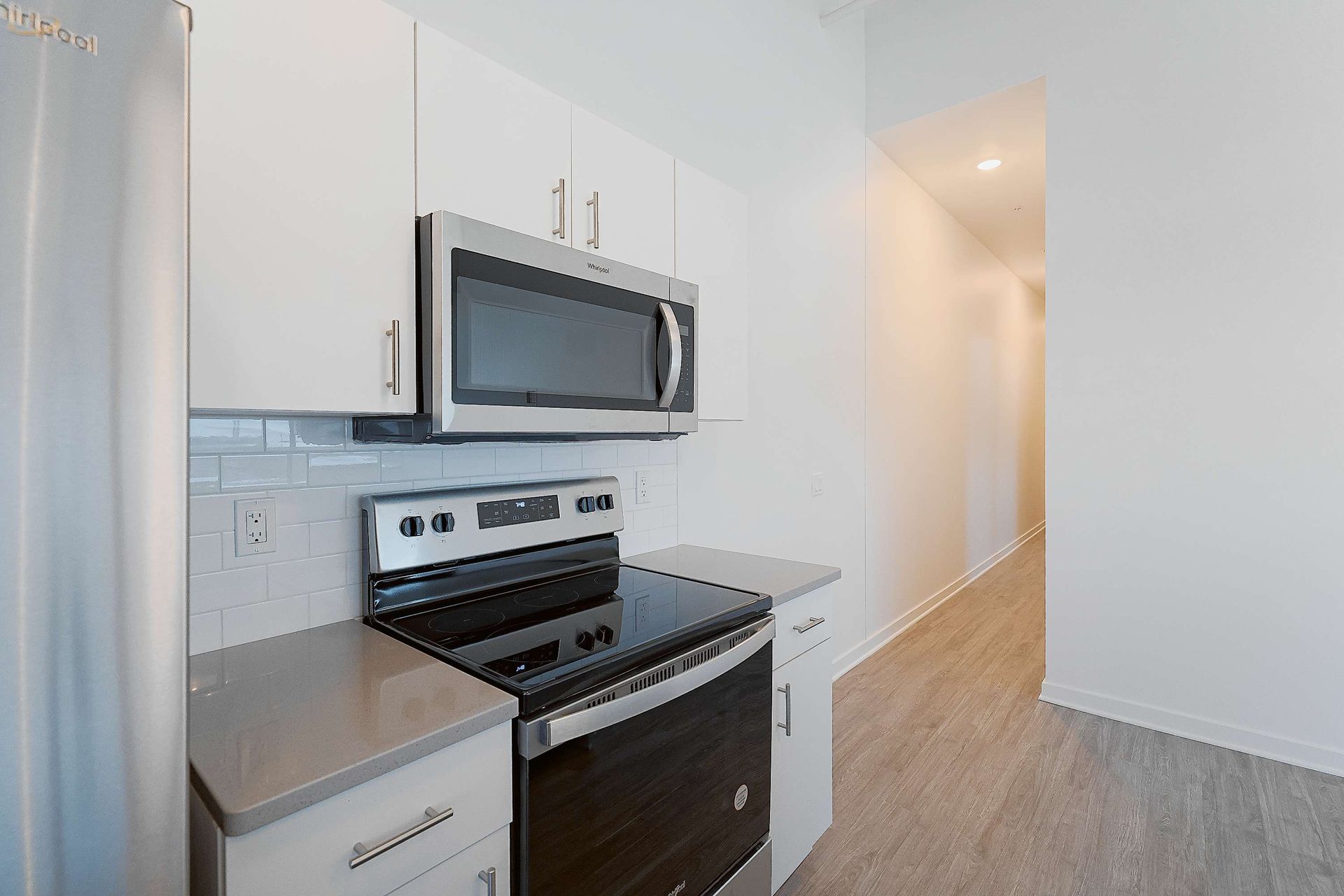 A kitchen with a stove , microwave , and refrigerator.