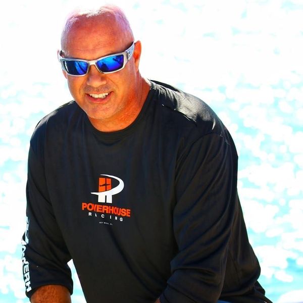 A man wearing sunglasses and a black powerhouse shirt