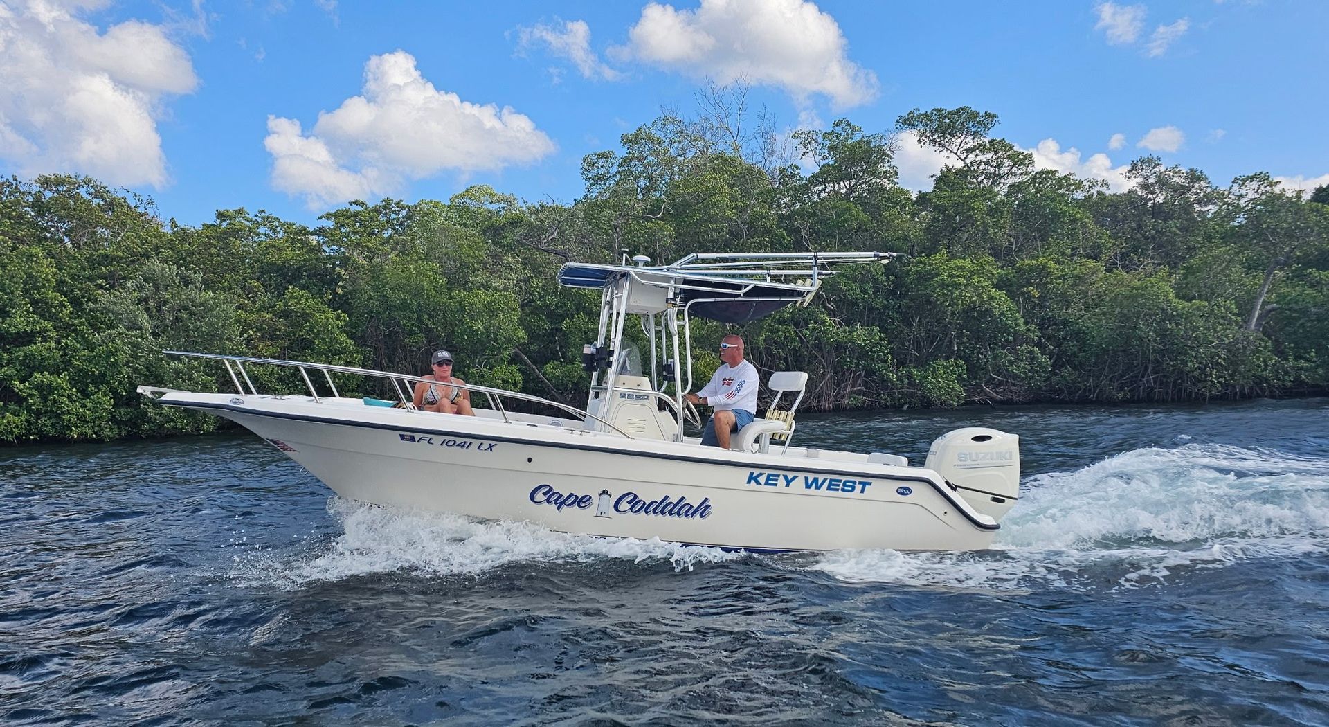 A white boat is floating on top of a body of water.