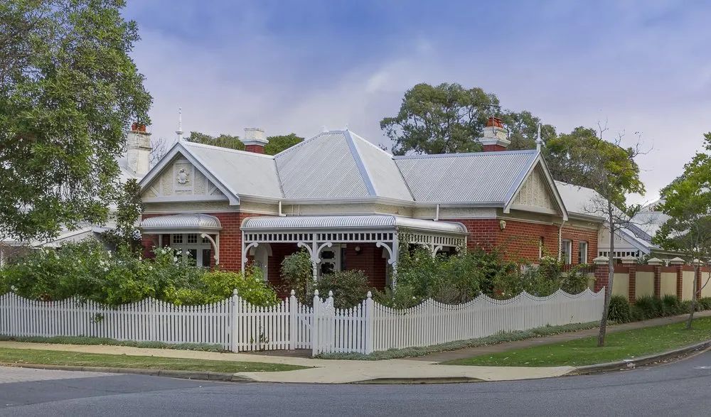 Red Brick House with White Picket Fence, Porch, and Metal Roof on a Corner Lot — Lawyers in Dubbo, NSW