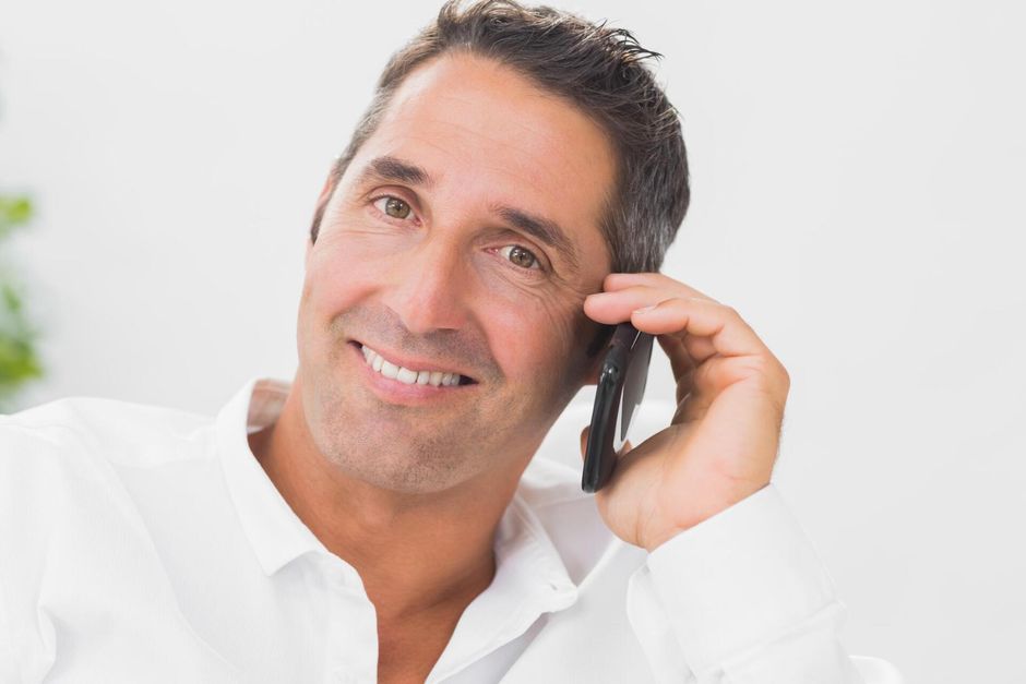 a man happily taking phone call