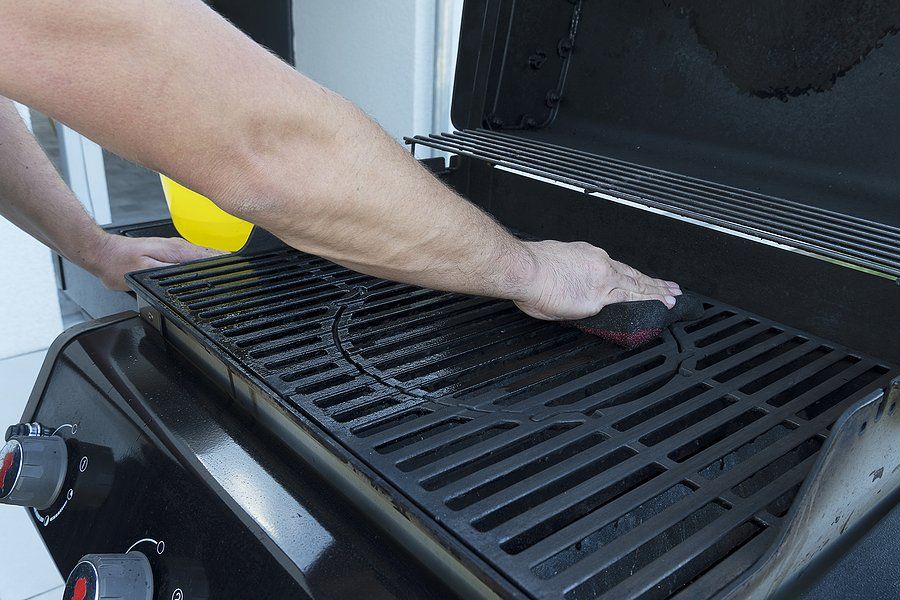 unrecognized person cleaning the grill using sponge