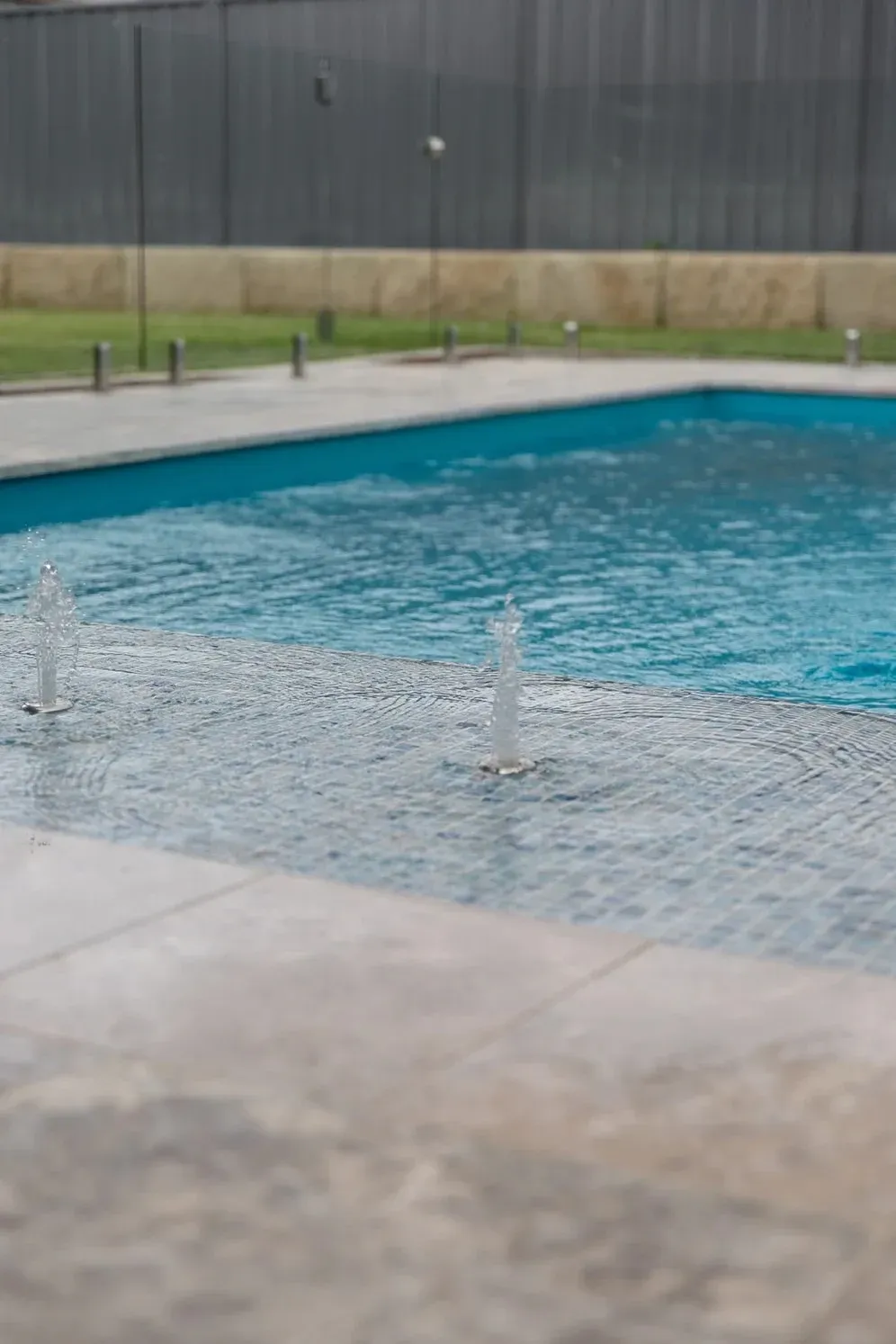 A Swimming Pool with A Fountain in The Middle of It — Billabong Pool Co in Smeaton Grange, NSW