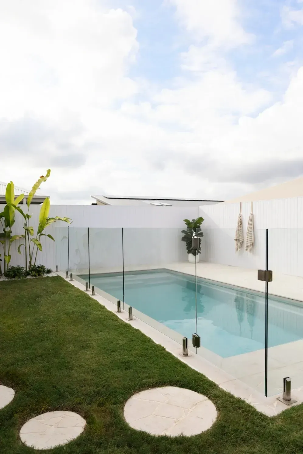 A Large Swimming Pool Is Surrounded by A Glass Fence — Billabong Pool Co in Smeaton Grange, NSW
