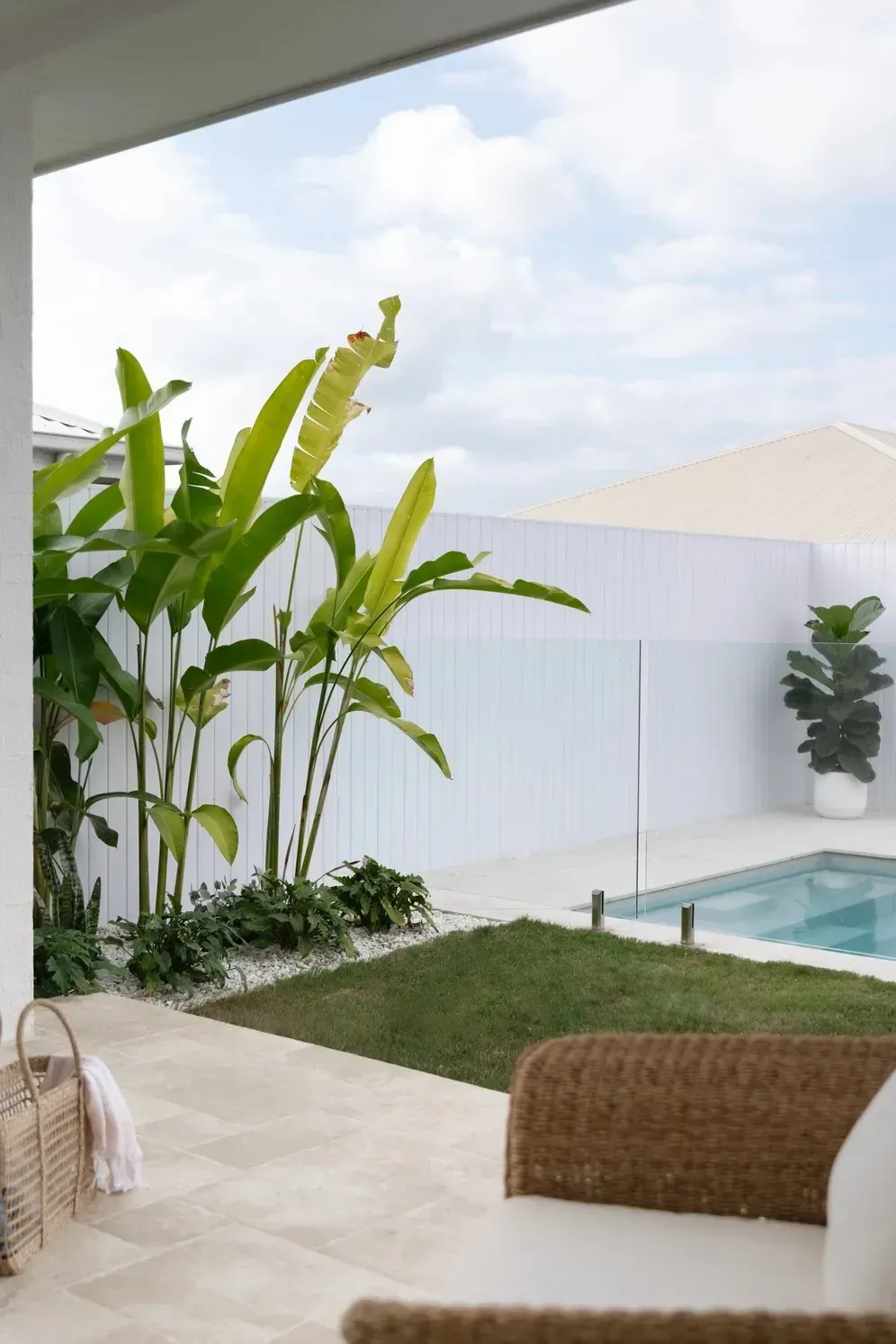 A Patio with A Wicker Chair and A Swimming Pool — Billabong Pool Co in Smeaton Grange, NSW