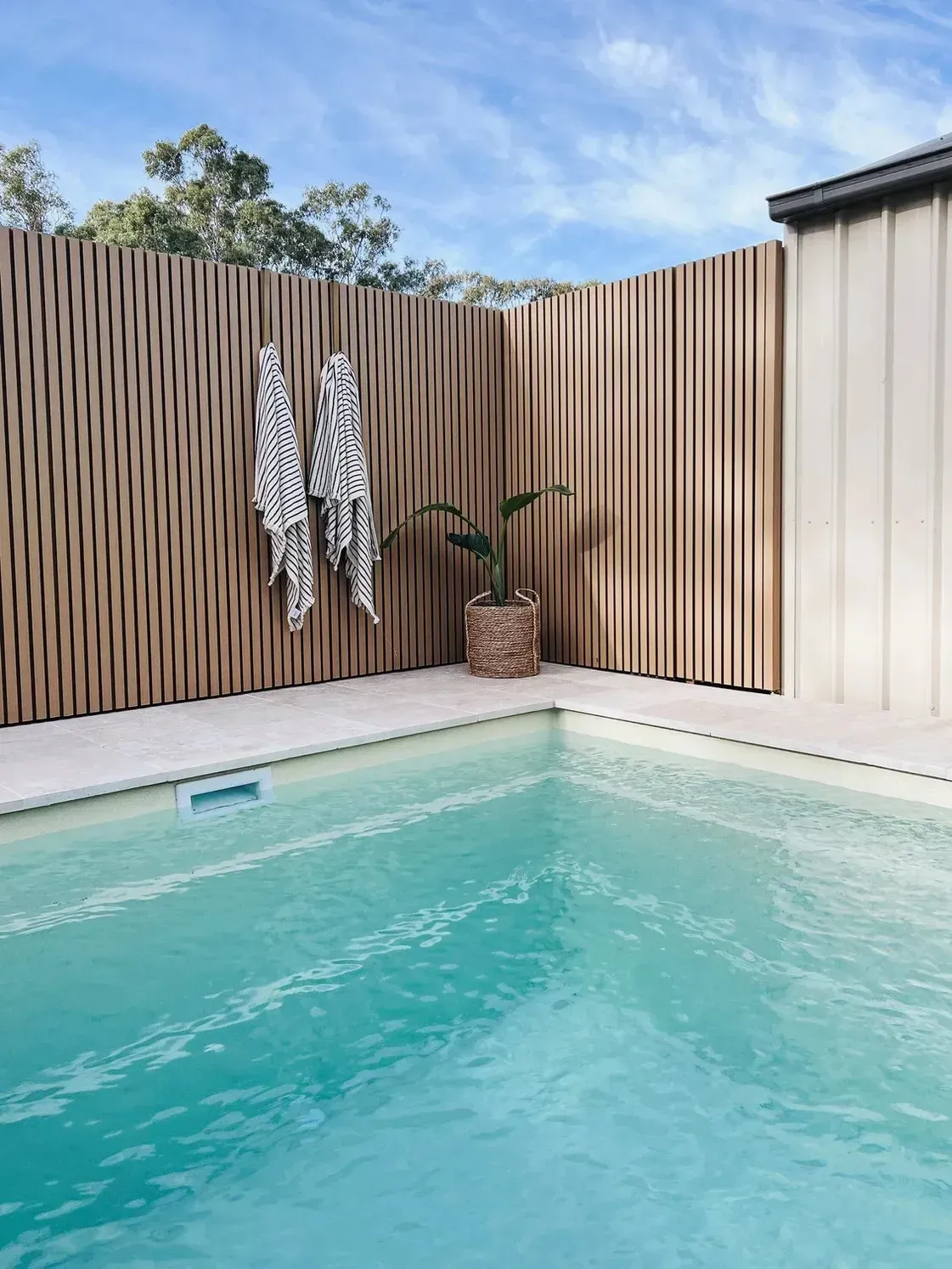 A Swimming Pool Surrounded by A Wooden Fence — Billabong Pool Co in Smeaton Grange, NSW