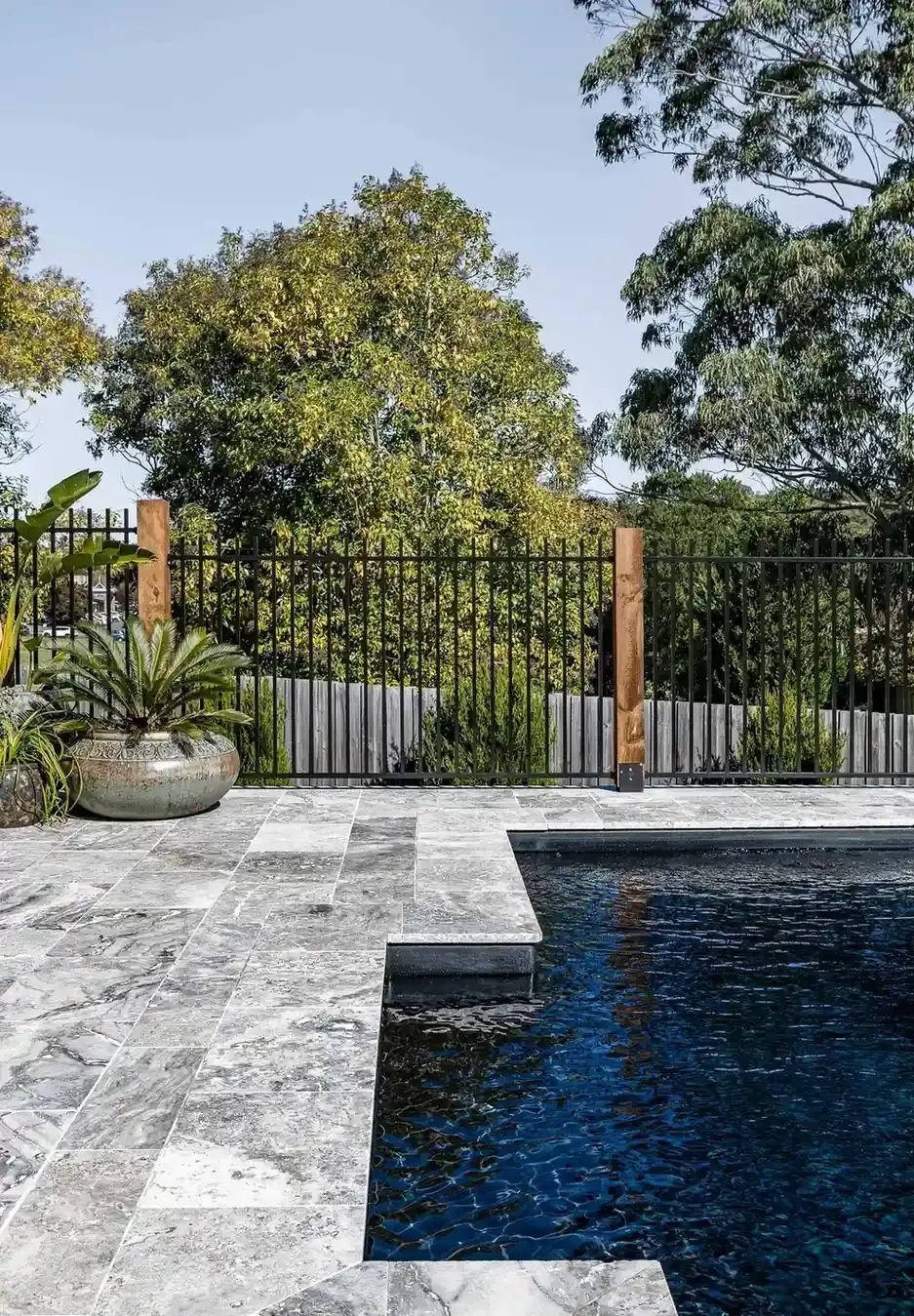 A Large Swimming Pool Surrounded by A Fence and Trees — Billabong Pool Co in Smeaton Grange, NSW