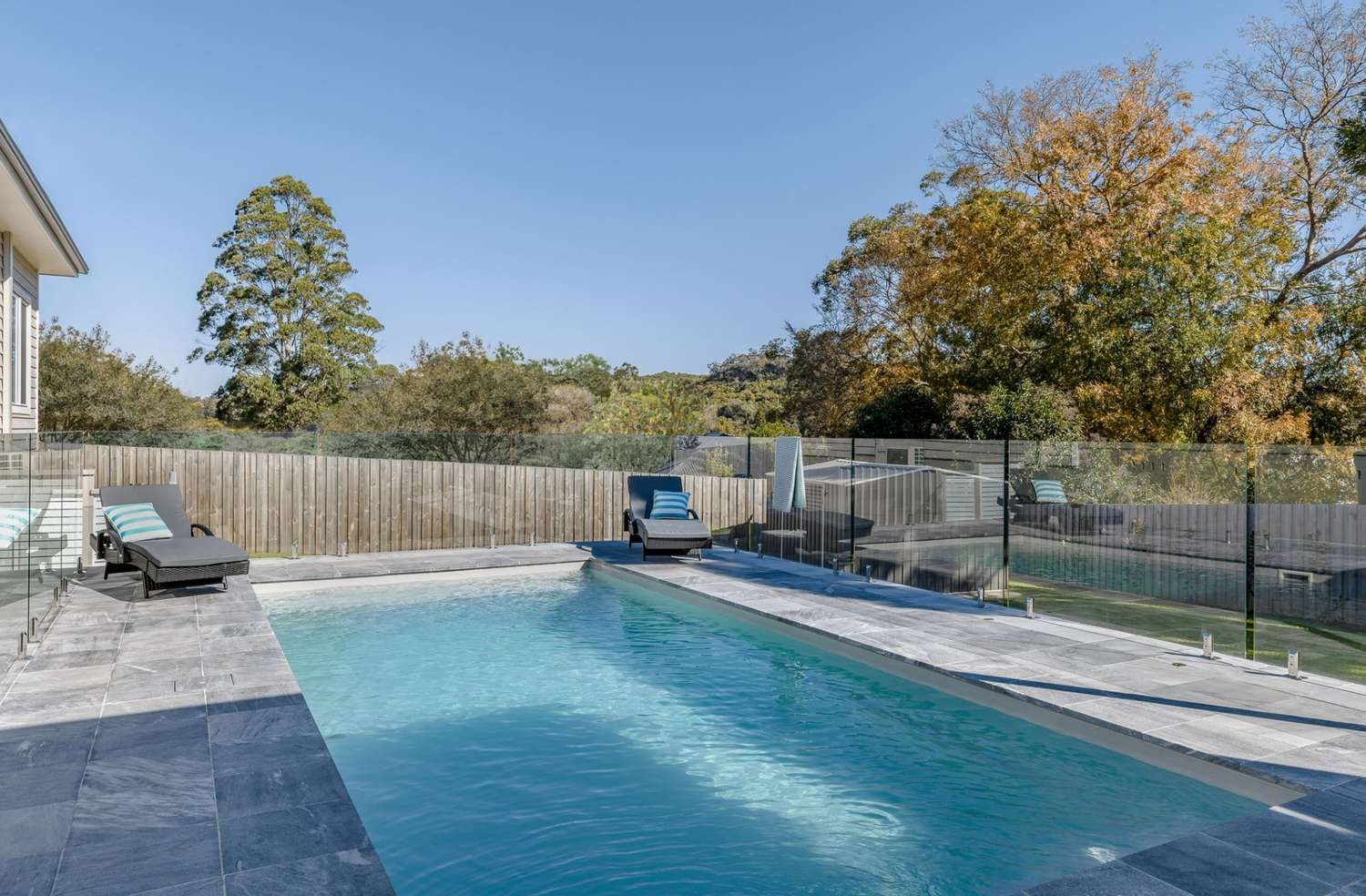 A Large Swimming Pool in The Backyard of A House — Billabong Pool Co in Smeaton Grange, NSW