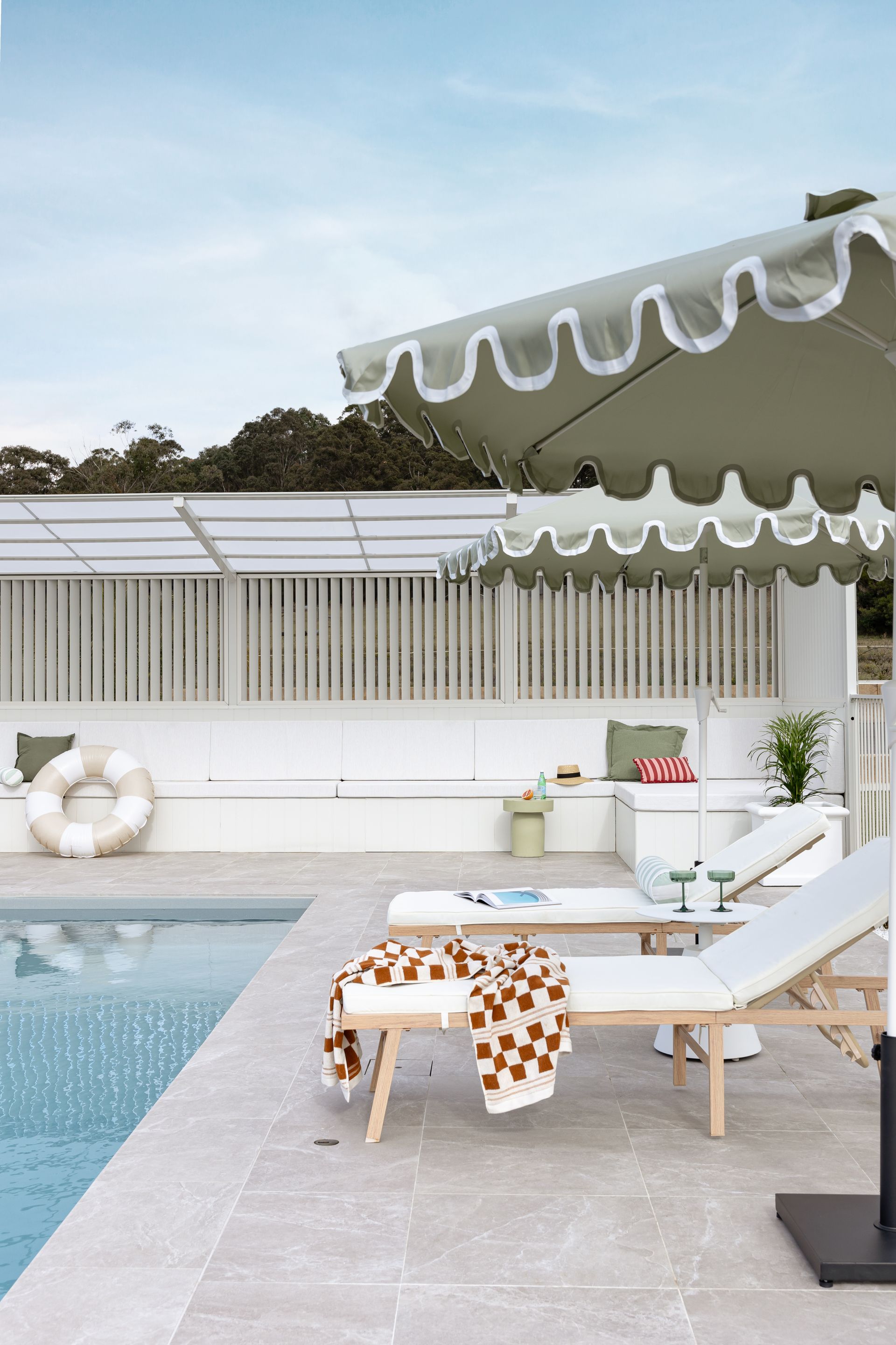 A Large Swimming Pool with Umbrellas and Chairs — Billabong Pool Co in Smeaton Grange, NSW