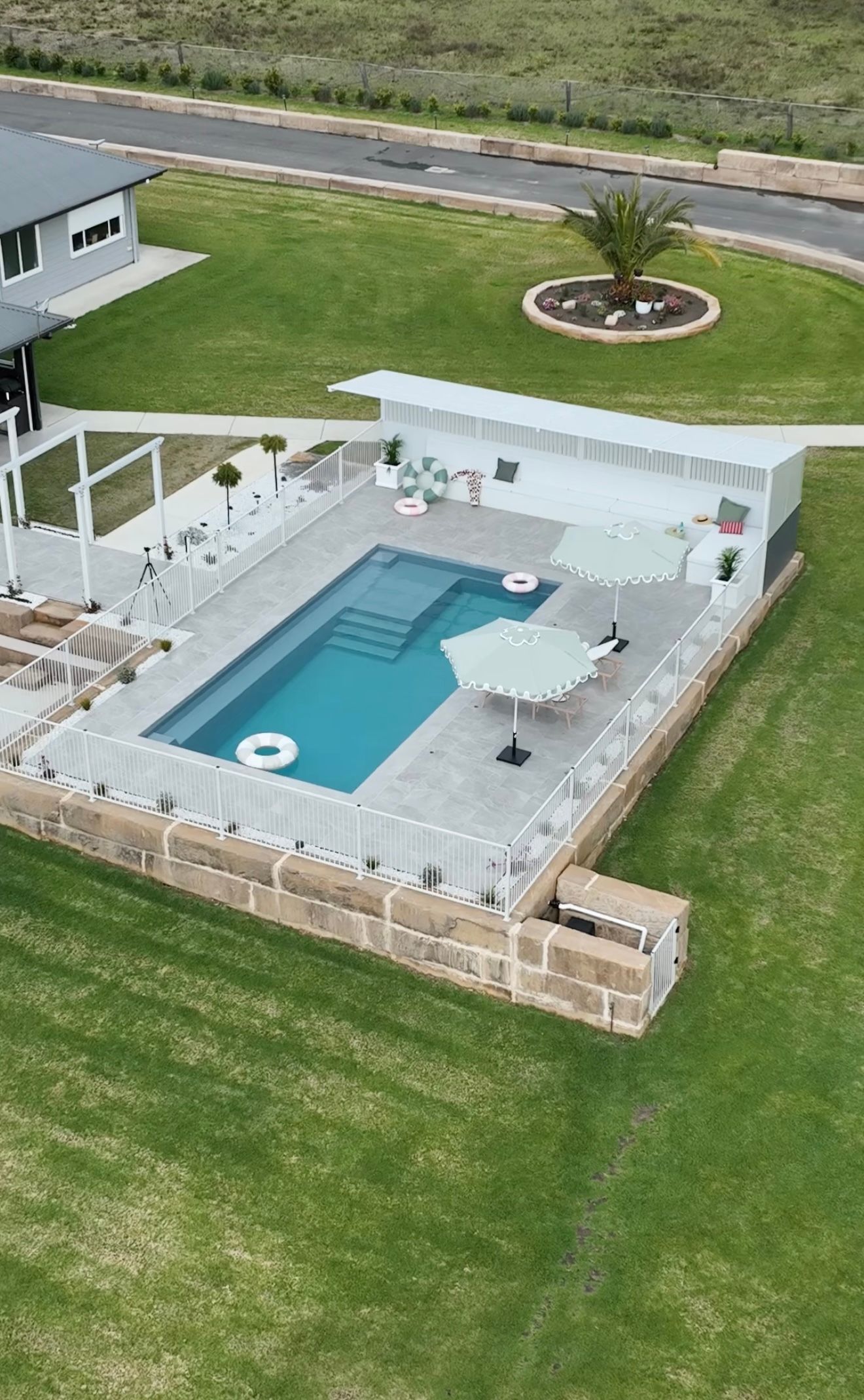 A Swimming Pool Surrounded by A Wooden Fence — Billabong Pool Co in Smeaton Grange, NSW