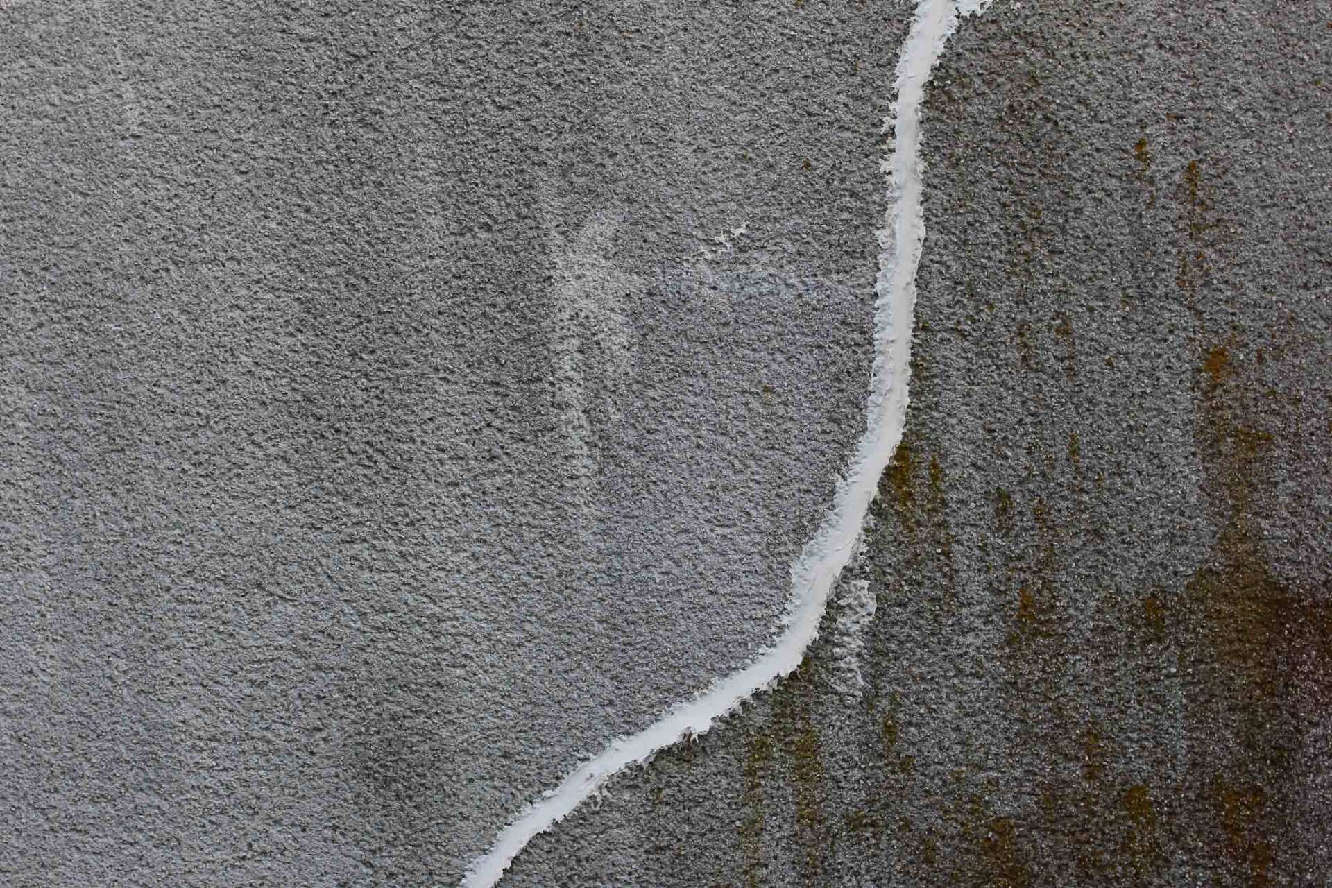 Concrete Wall With Crack Repaired With White Concrete Patching Putty - Warren, MI - Maple Lane Pest Control