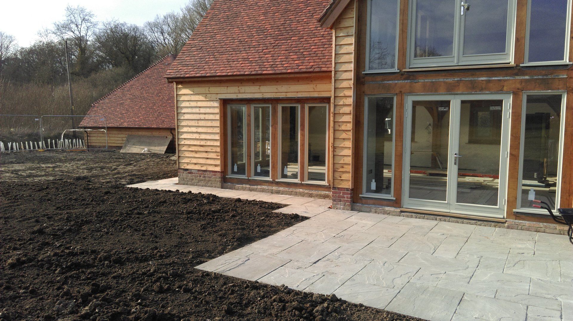 A house with a lot of windows and a patio in front of it