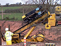 A man is standing next to a large yellow machine.