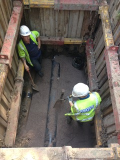 Davis Groundworks | Two construction workers are working in a hole in the ground.