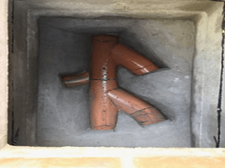 Davis Groundworks | A close up of a hole in a wall with pipes in it